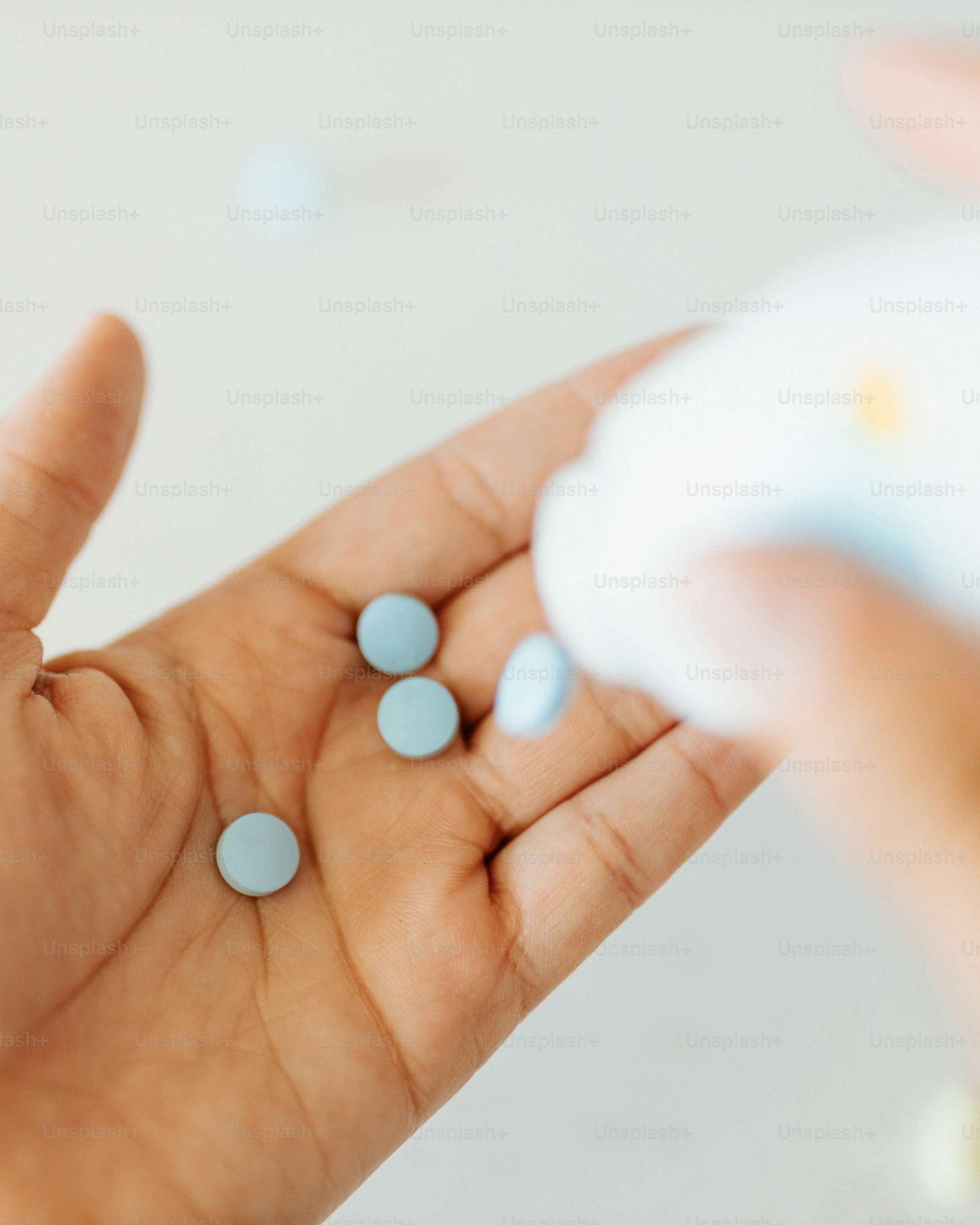 a person holding three pills in their hand