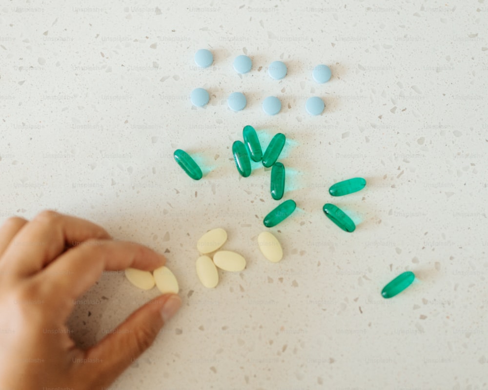Una mano sta raccogliendo pillole da un tavolo