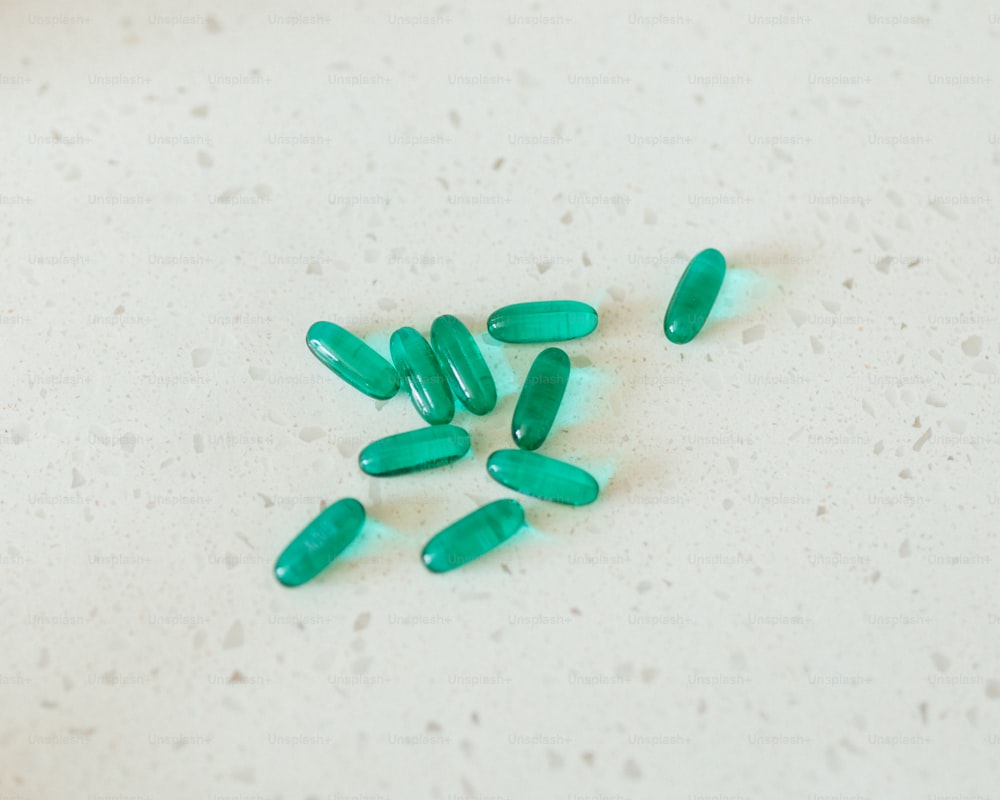 um monte de pílulas verdes sentadas em cima de uma mesa