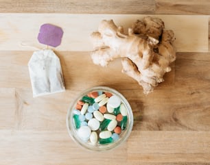 a bowl of pills and ginger root on a table