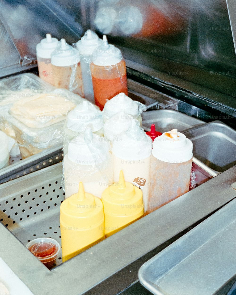 a sink filled with lots of bottles of food