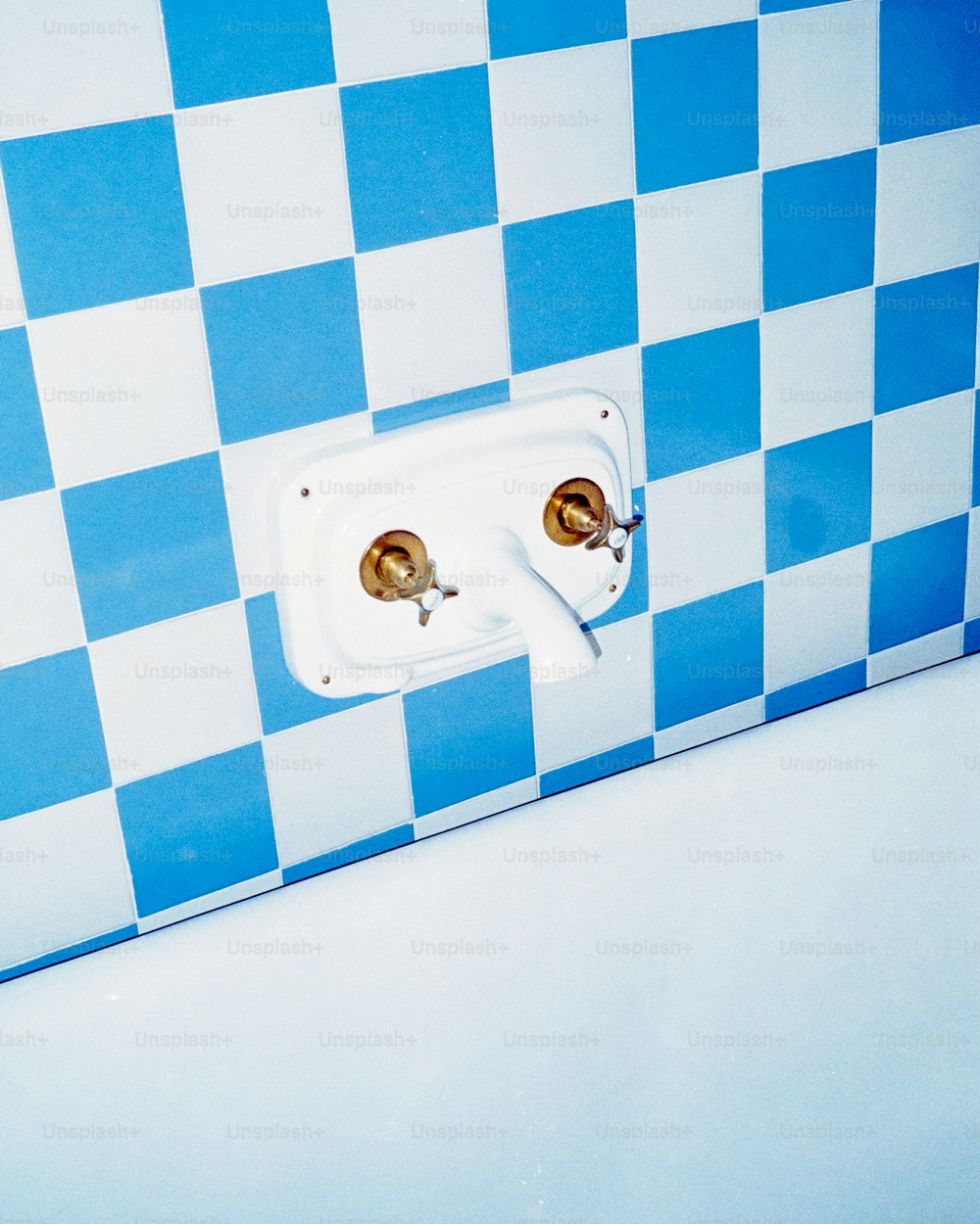 un bagno con pareti a scacchi blu e bianchi