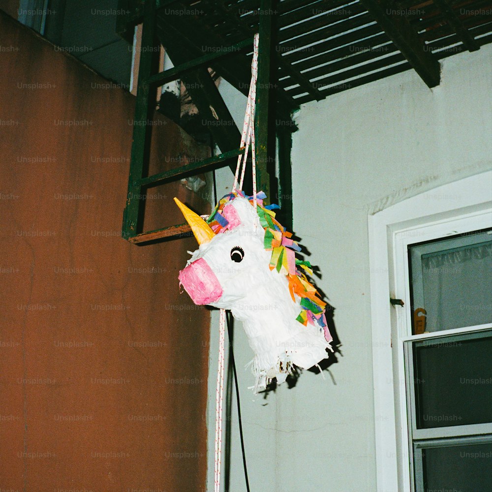 Un maché de papel de un unicornio colgando de un gancho