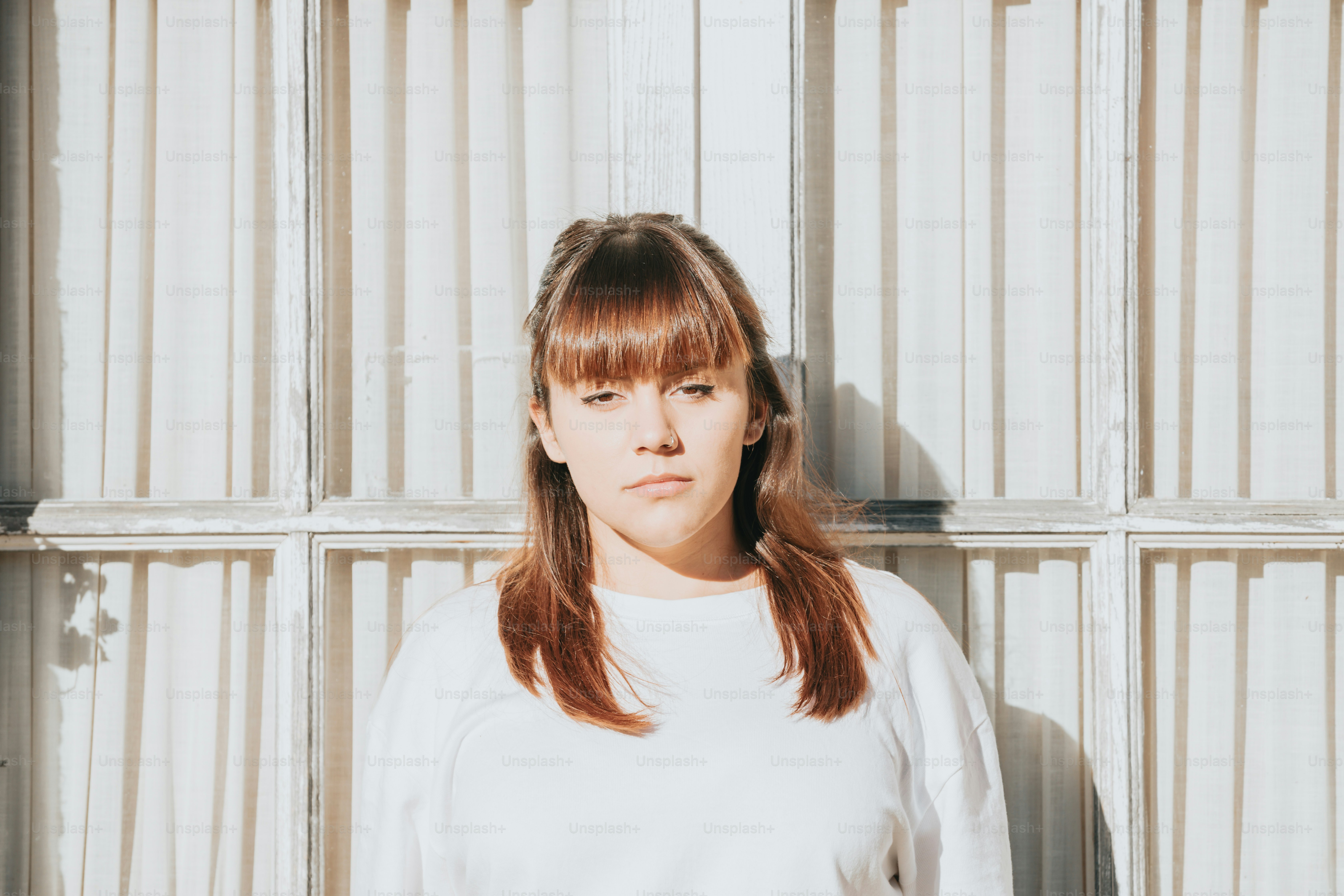 Une femme debout devant un mur blanc