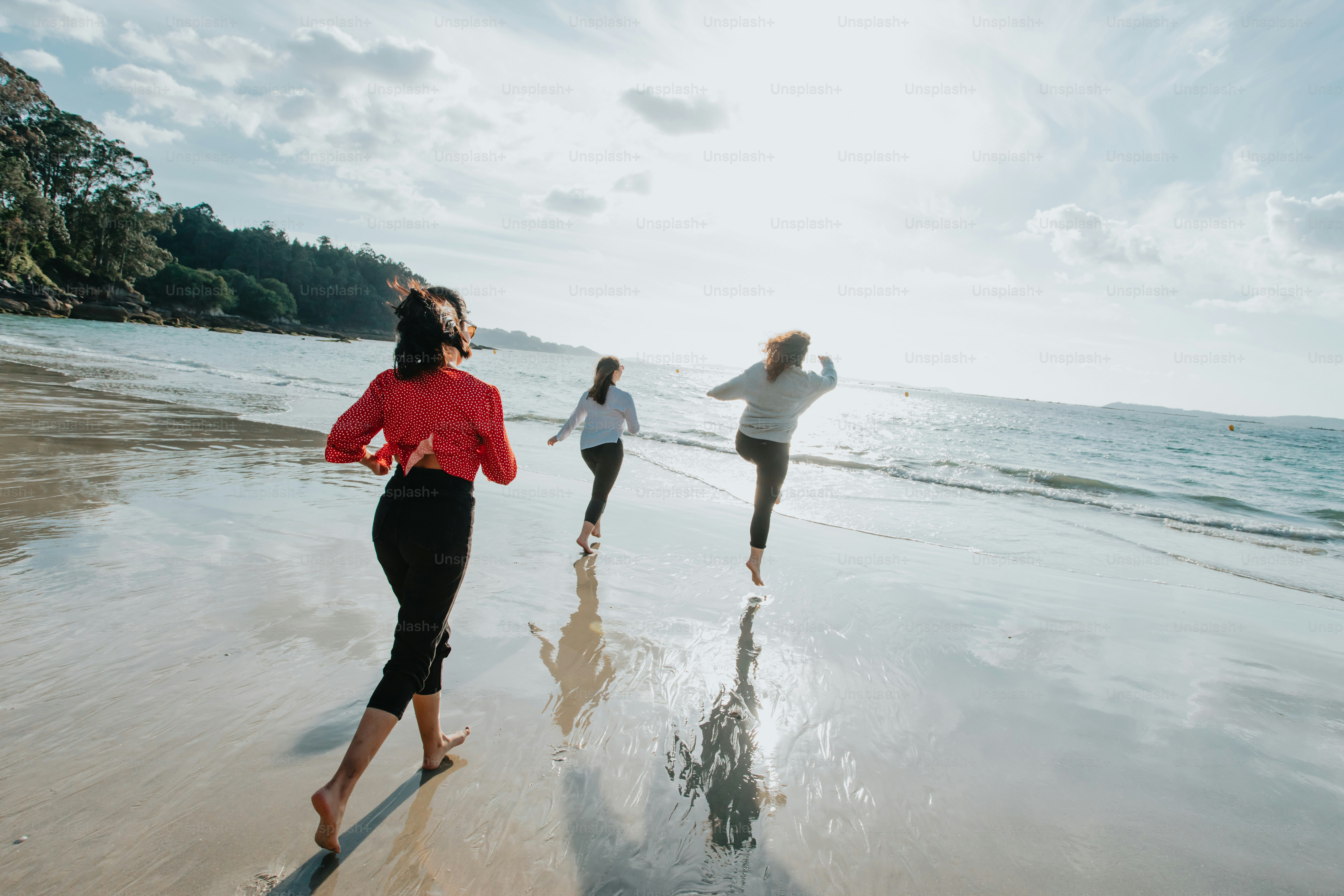 a group of people running along a beach