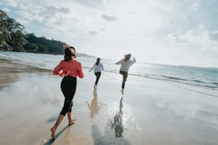 un gruppo di persone che corrono lungo una spiaggia