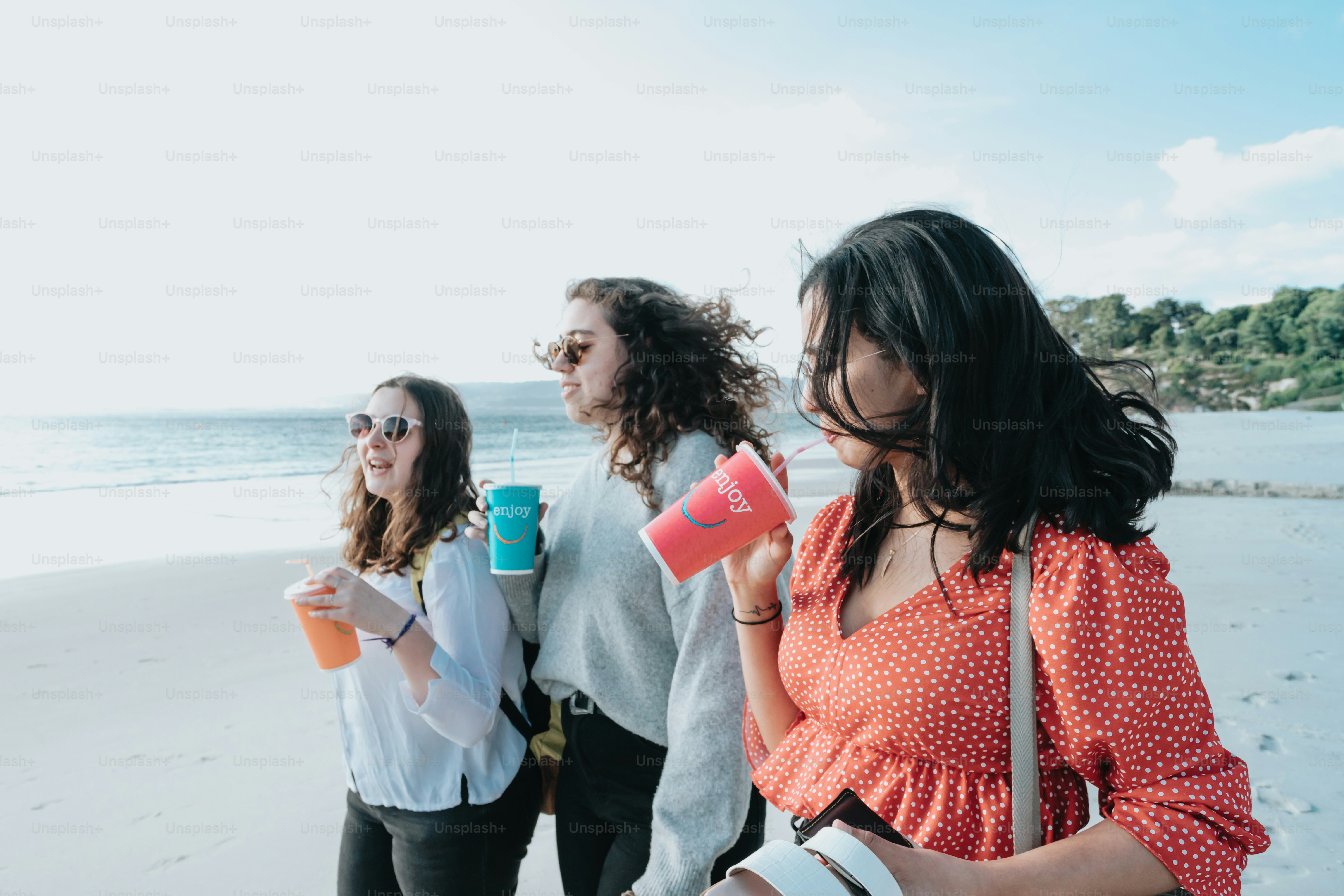 Un groupe de femmes debout au sommet d’une plage de sable
