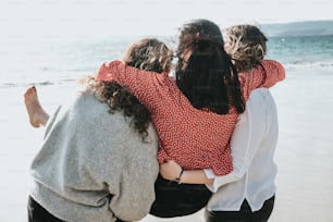 Un grupo de mujeres de pie una al lado de la otra en una playa