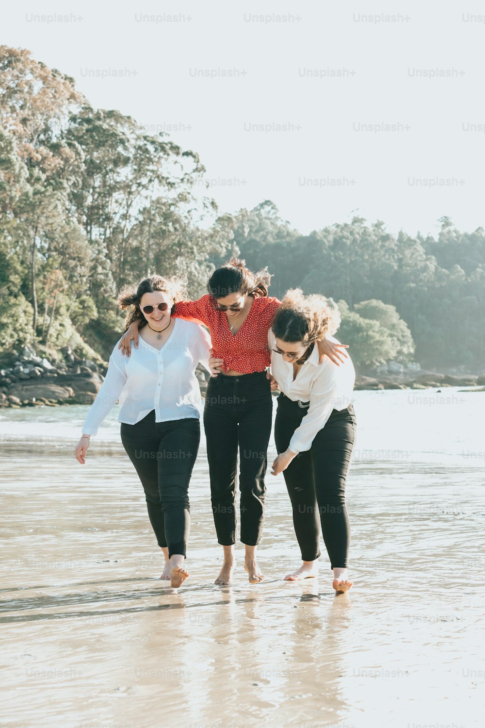 a group of people walking along a beach next to the ocean