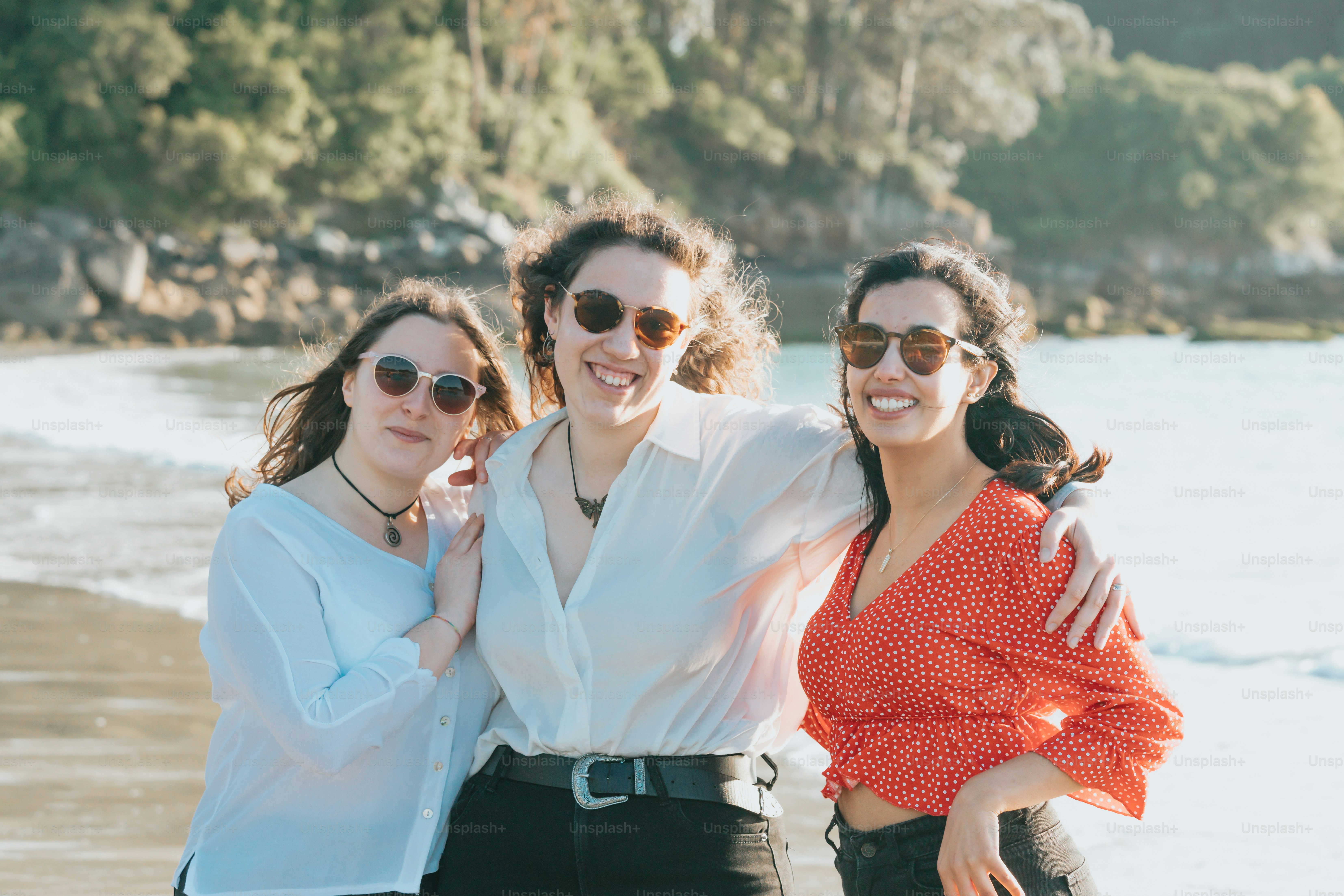 a group of women standing next to each other on a beach