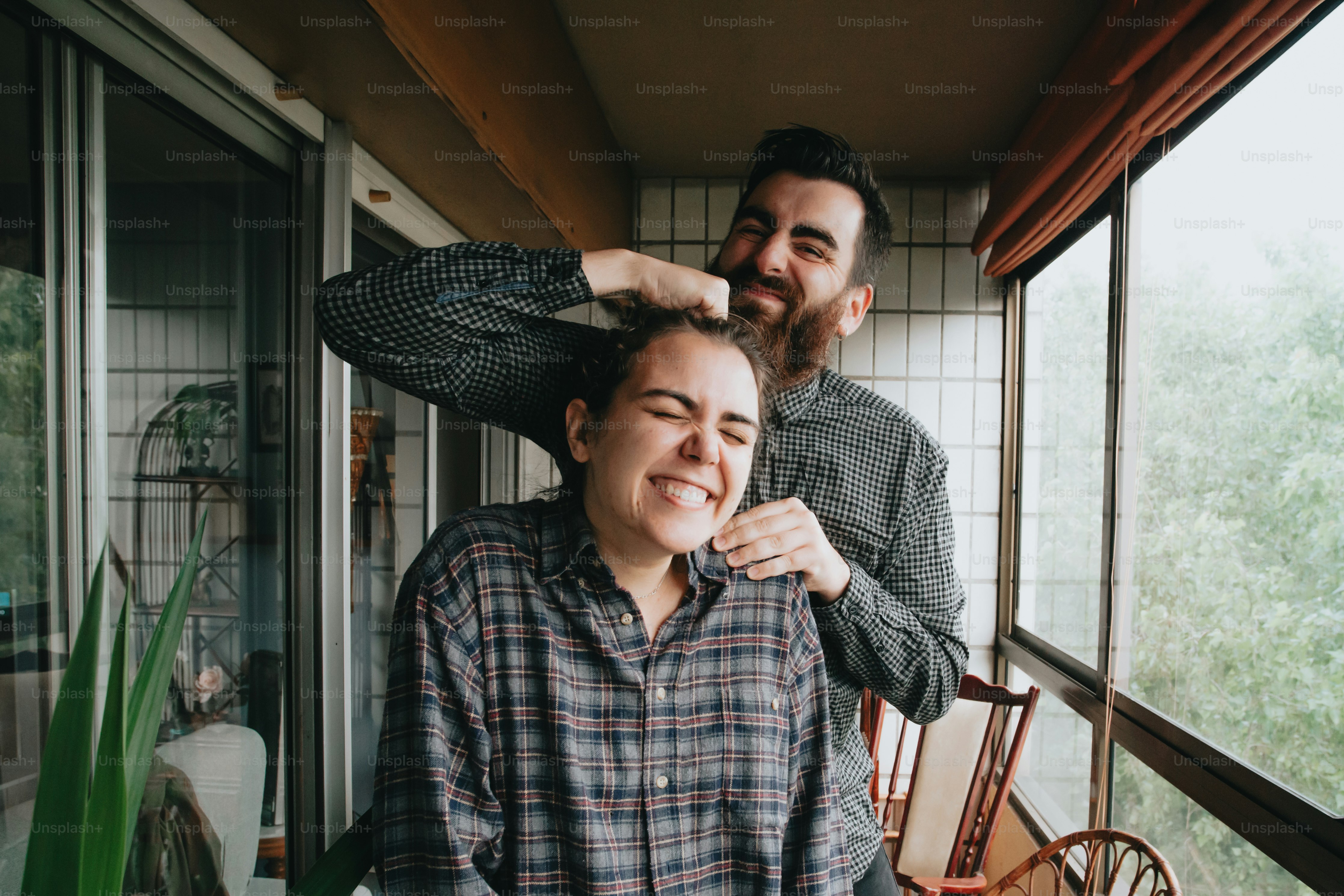 a man standing next to a woman who is brushing her hair
