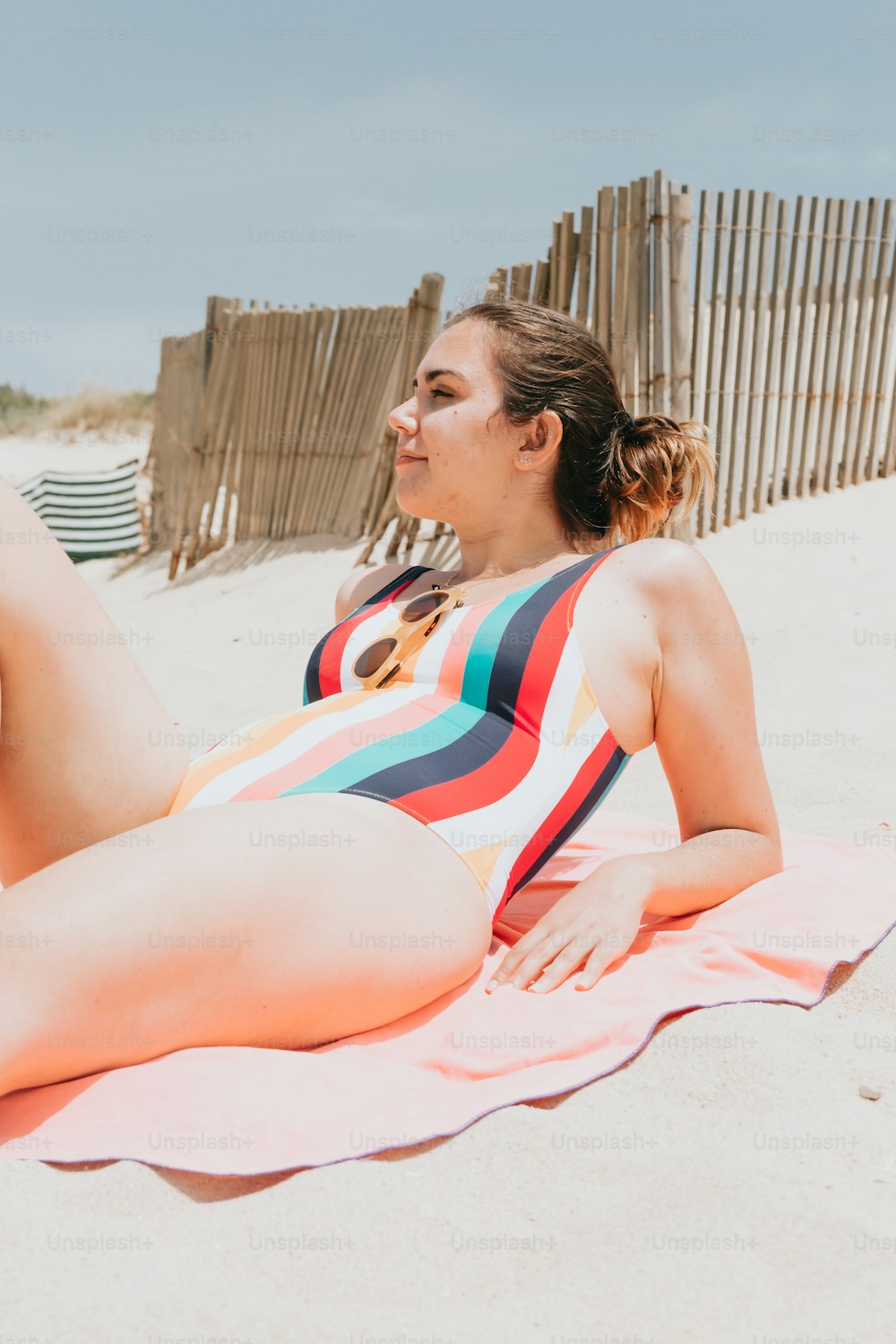 una donna che si posa su un asciugamano sulla spiaggia