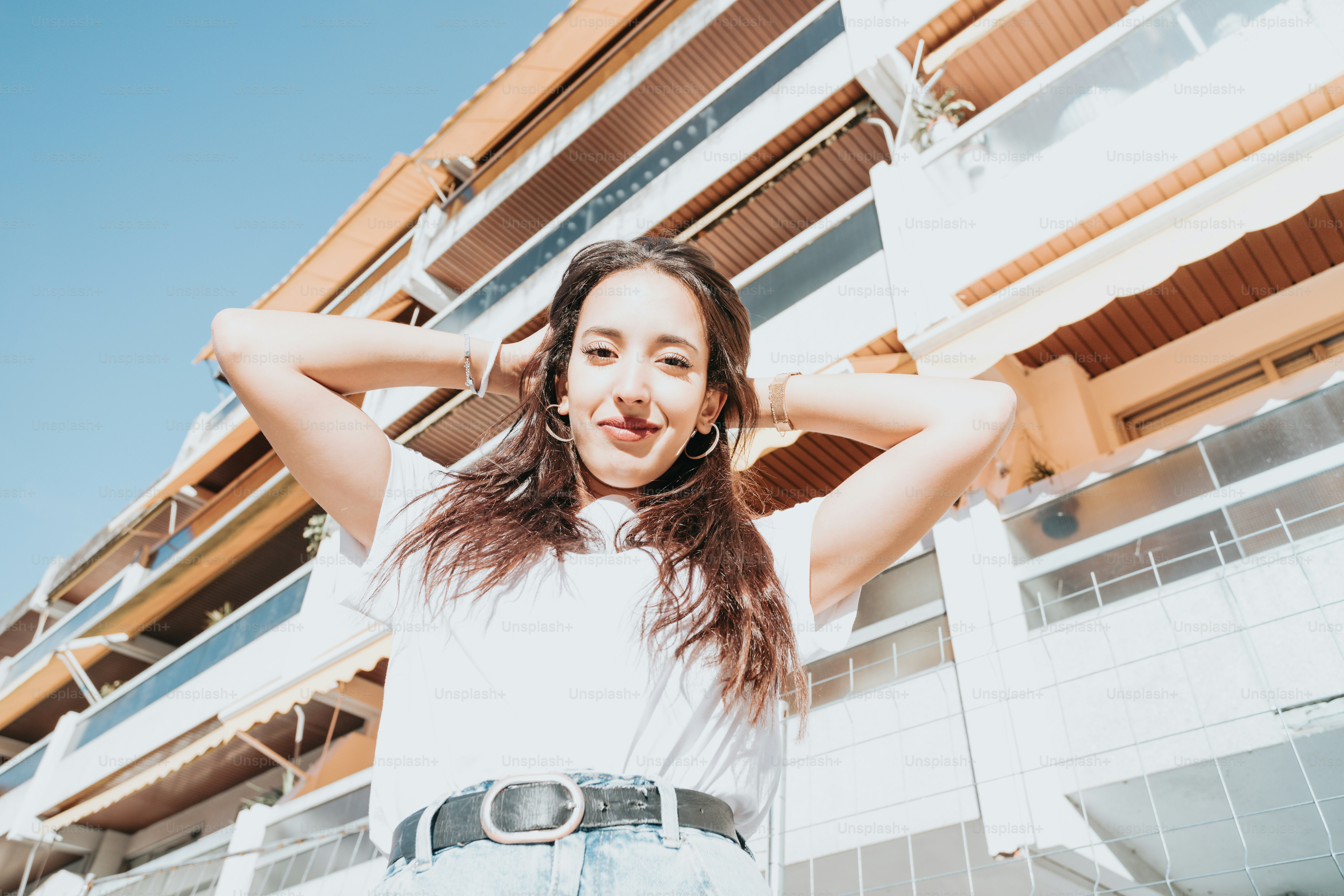 Une femme aux cheveux longs debout devant un immeuble