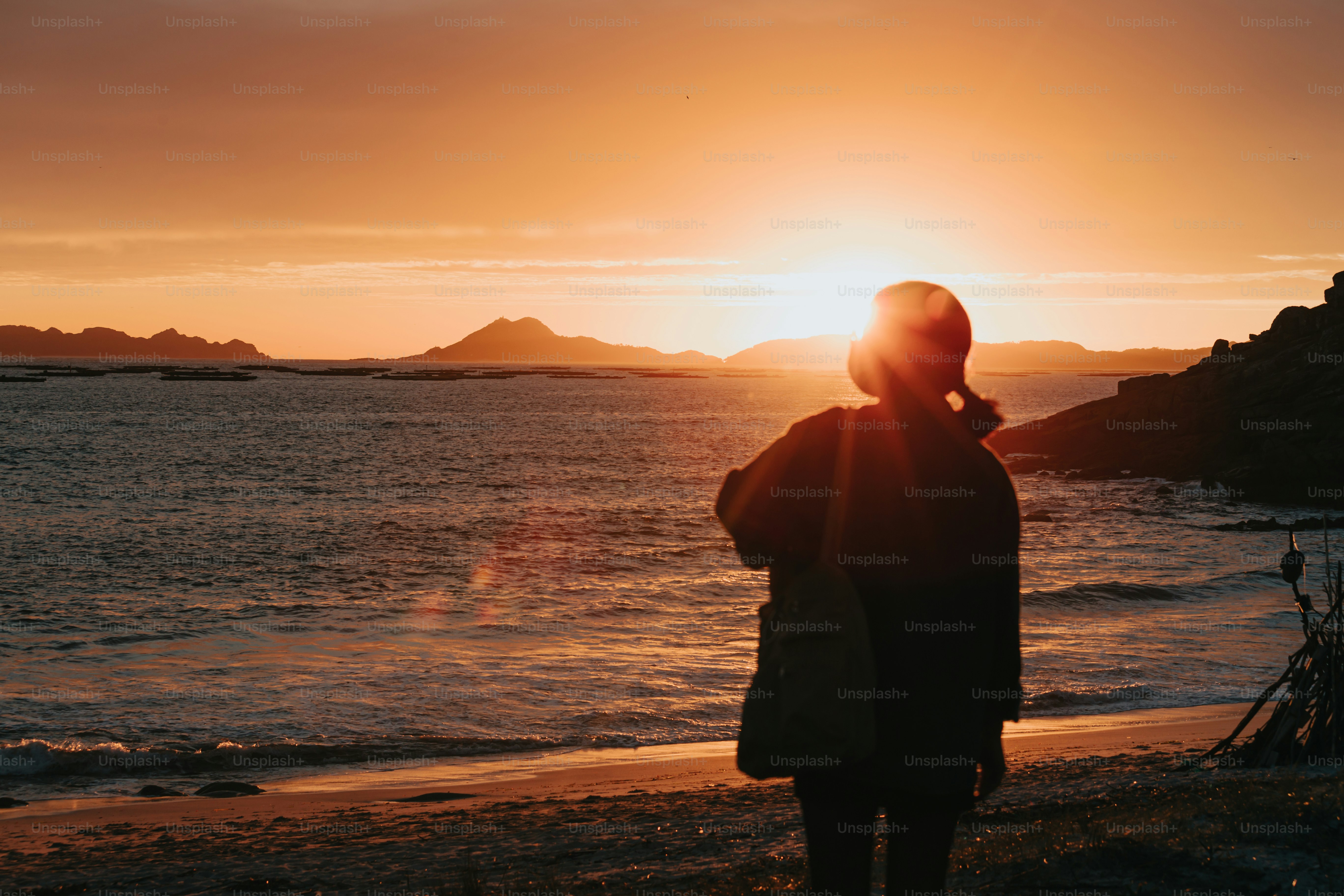 a person standing on a beach at sunset