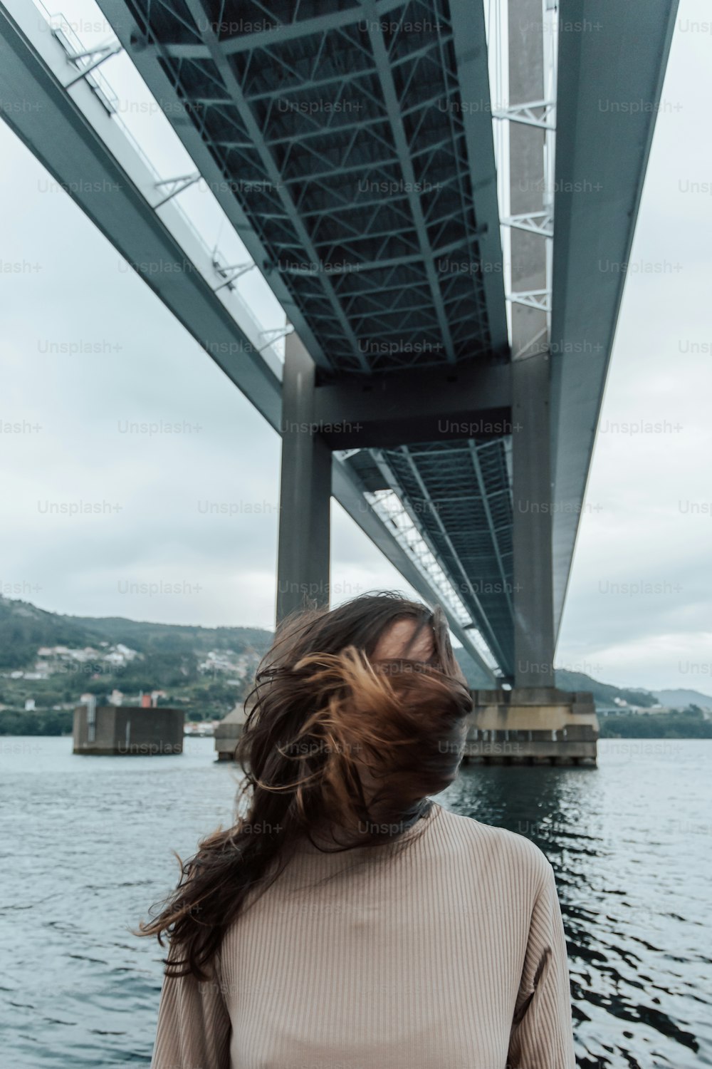 uma mulher em pé em frente a uma grande ponte