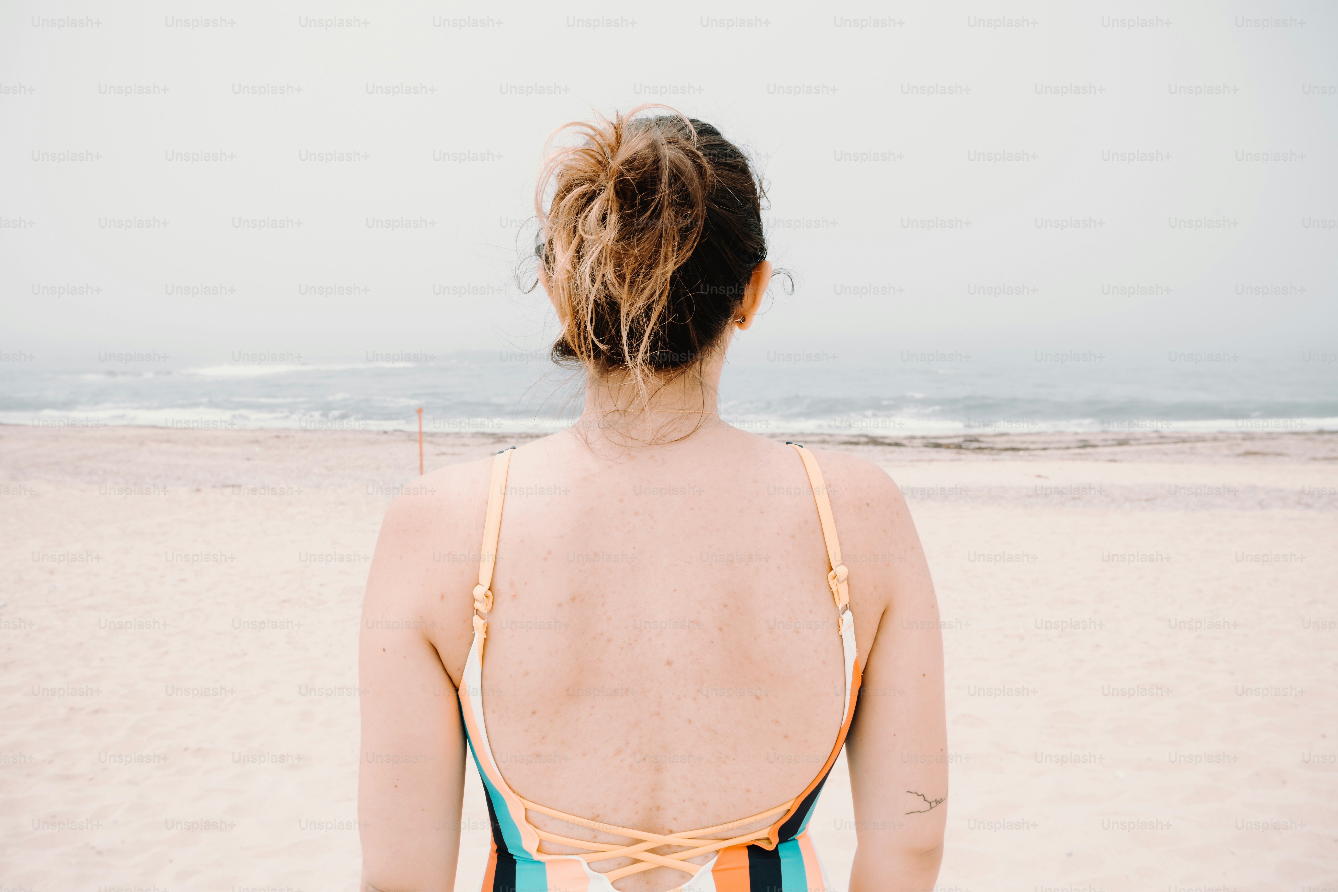 Une femme en maillot de bain debout sur une plage