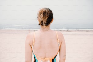 a woman in a bathing suit standing on a beach