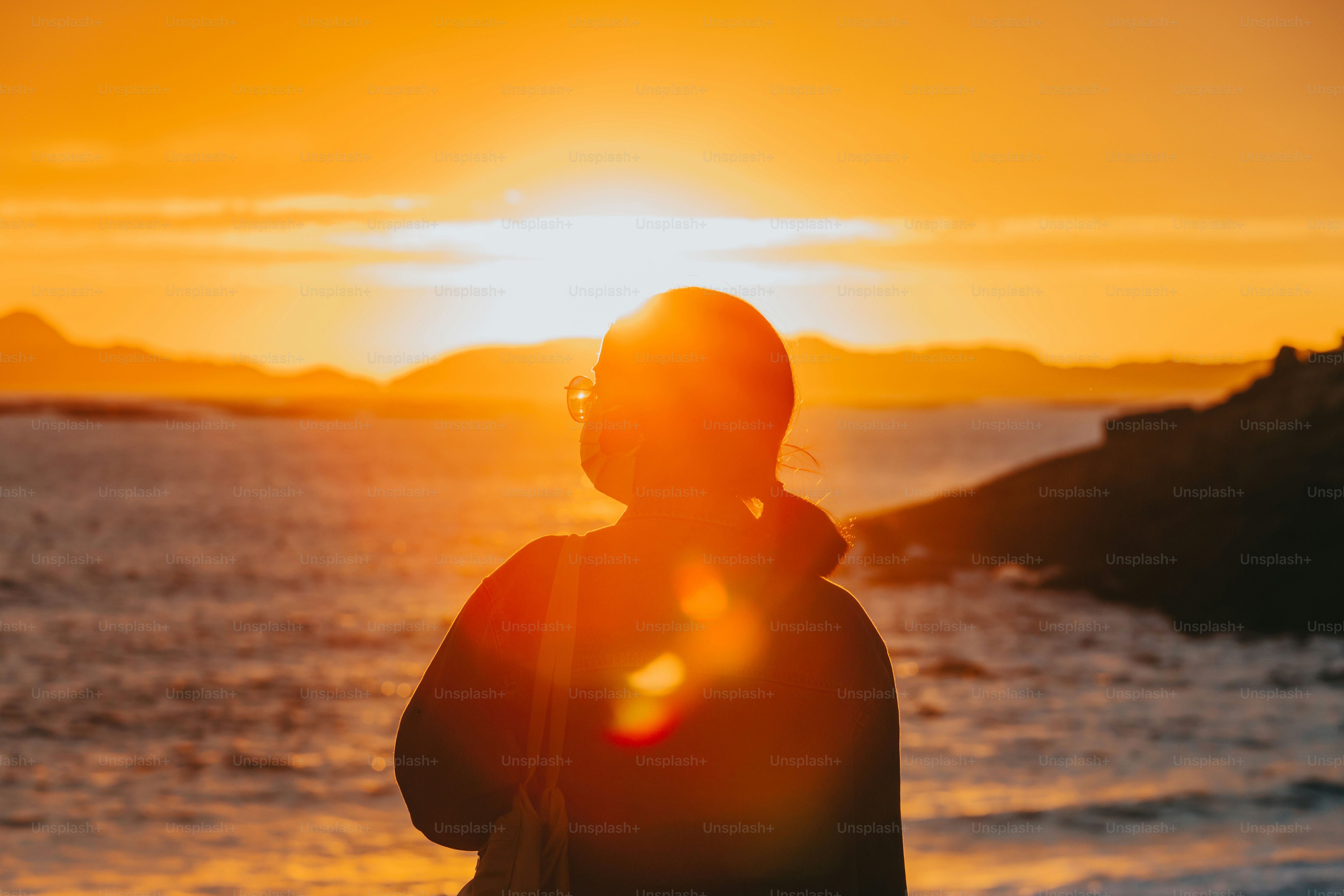 Foto Una persona parada frente a un cuerpo de agua – Amanecer Imagen en ...