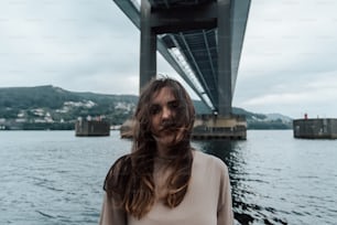 a woman standing in front of a large bridge