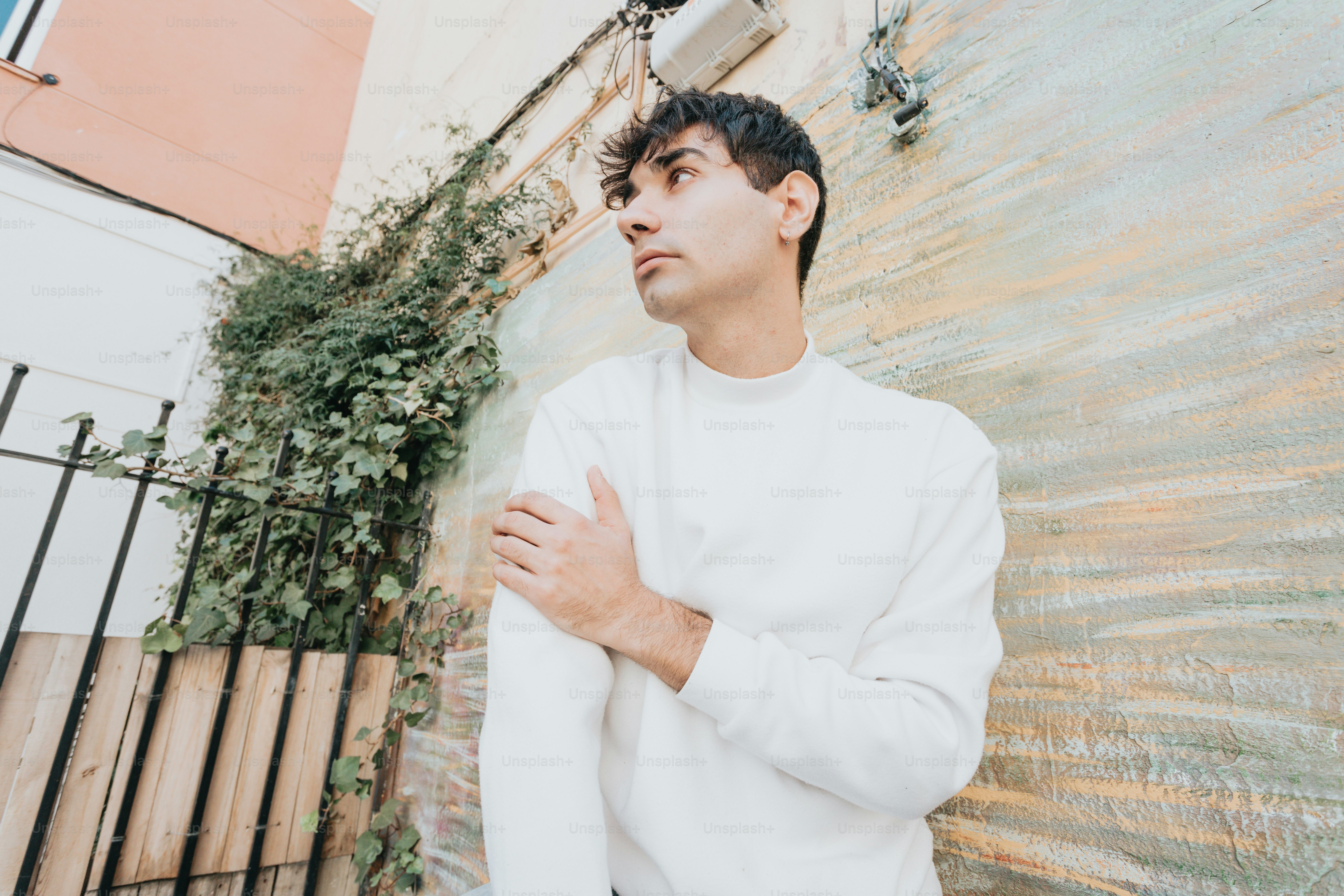 a man standing in front of a wall with his arms crossed