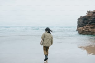 海の隣のビーチを歩く女性