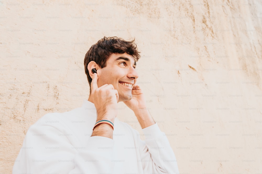 a man talking on a cell phone while wearing a white shirt