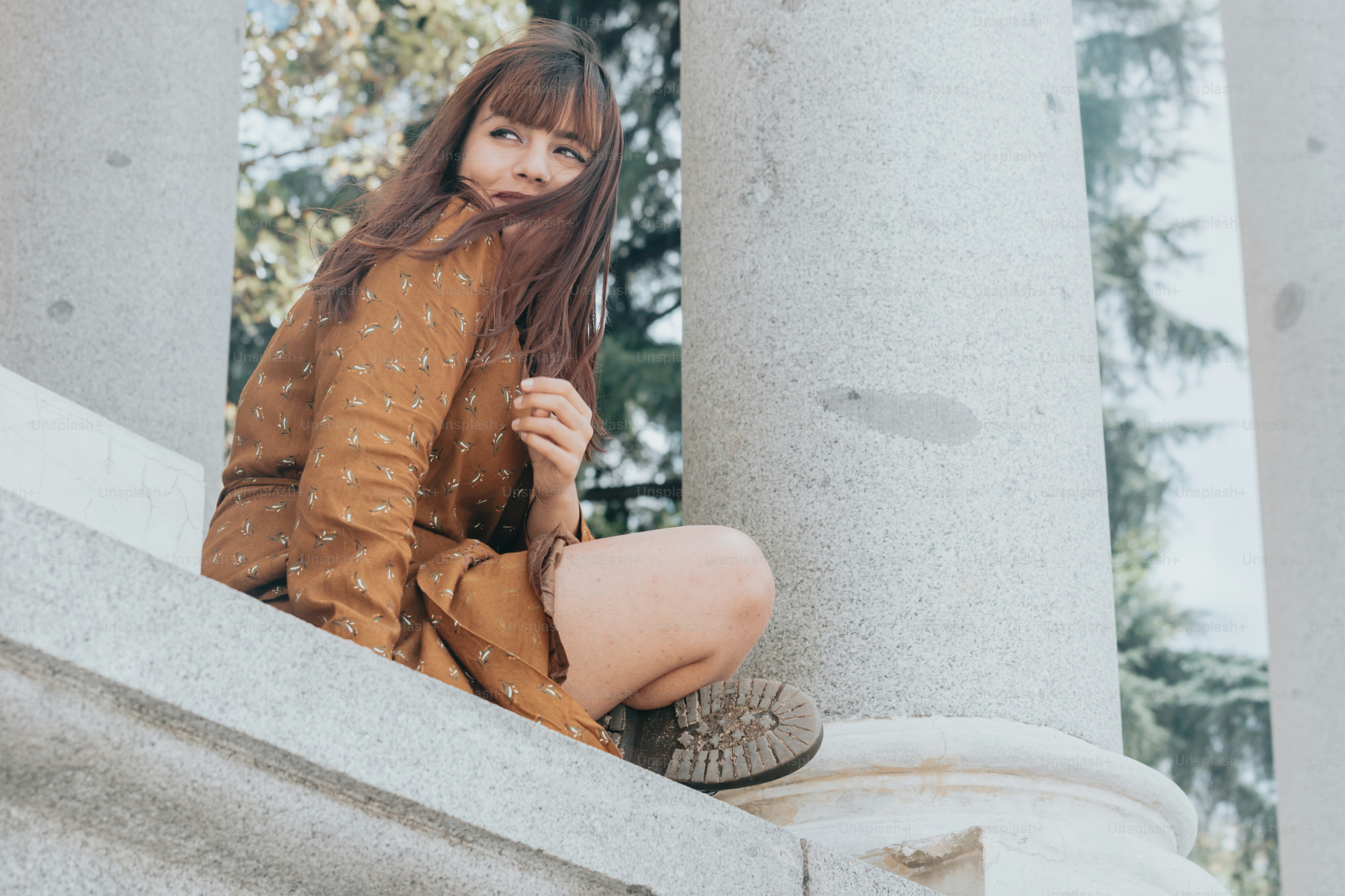 a woman is sitting on the steps of a building