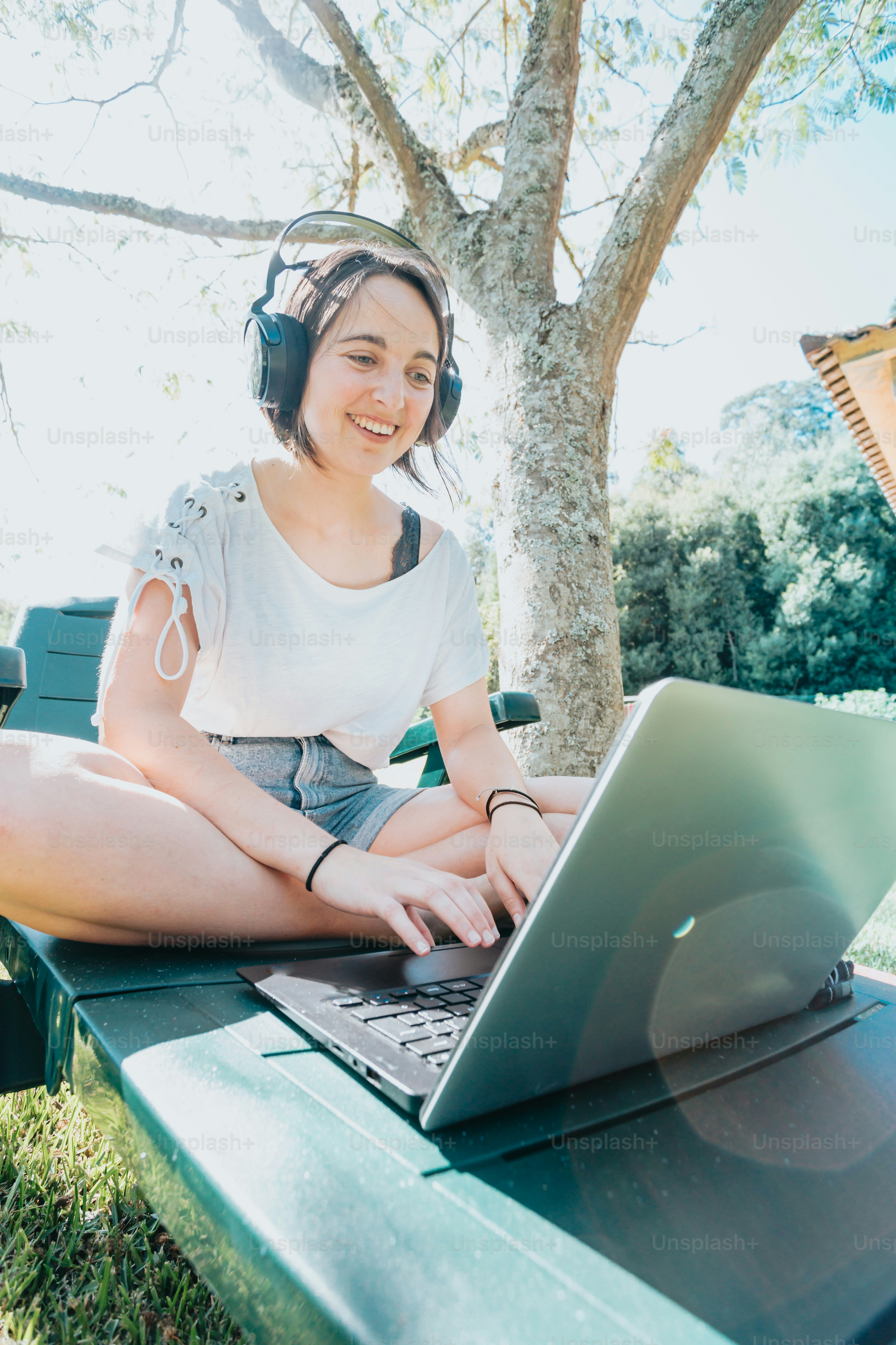 a woman sitting on a bench with a laptop