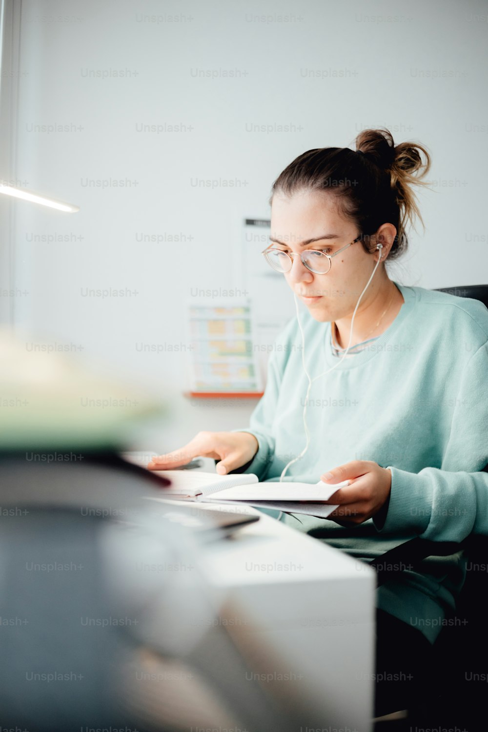 a woman sitting at a desk with headphones on