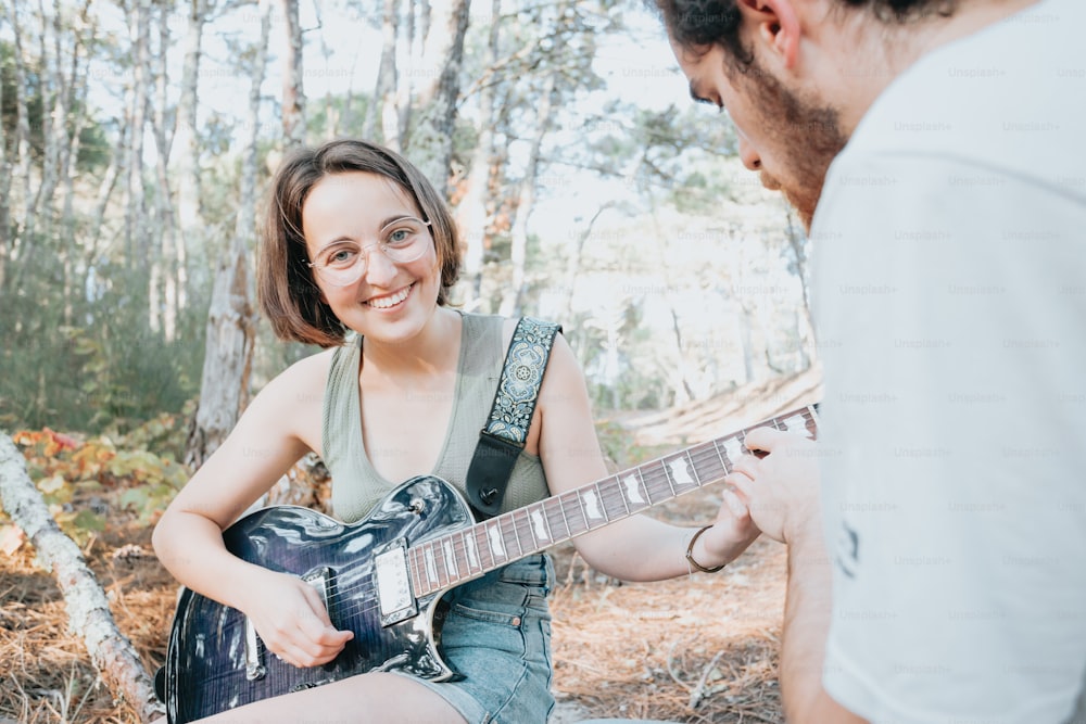 a man playing a guitar next to a woman