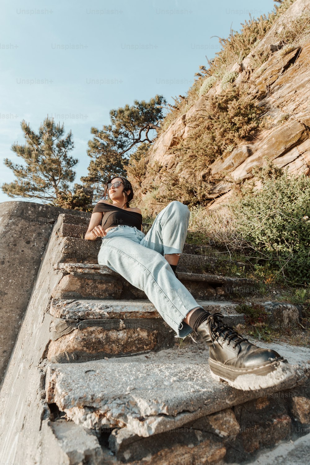 a man sitting on a stone wall with his legs crossed