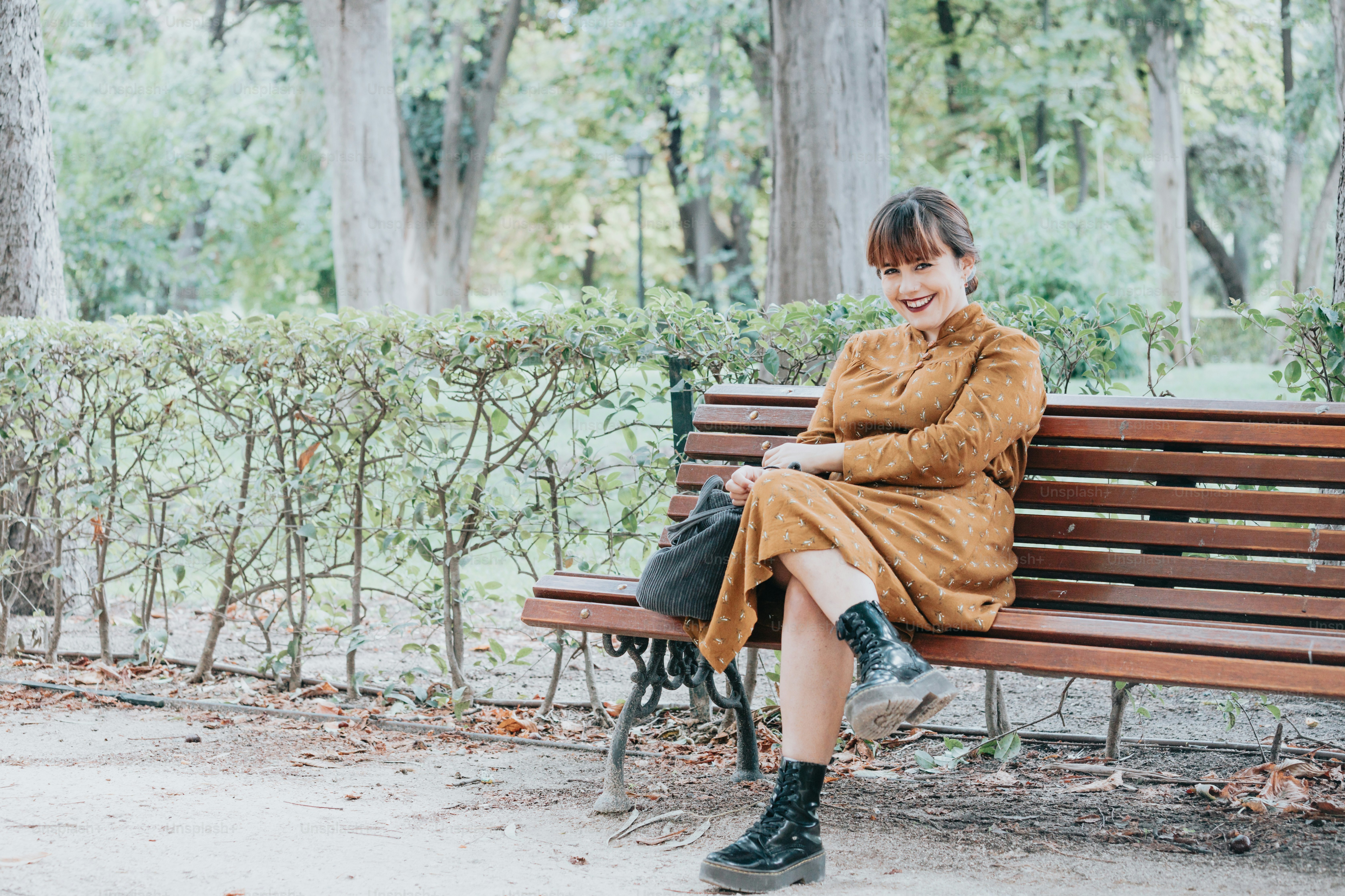 a woman sitting on a bench in a park