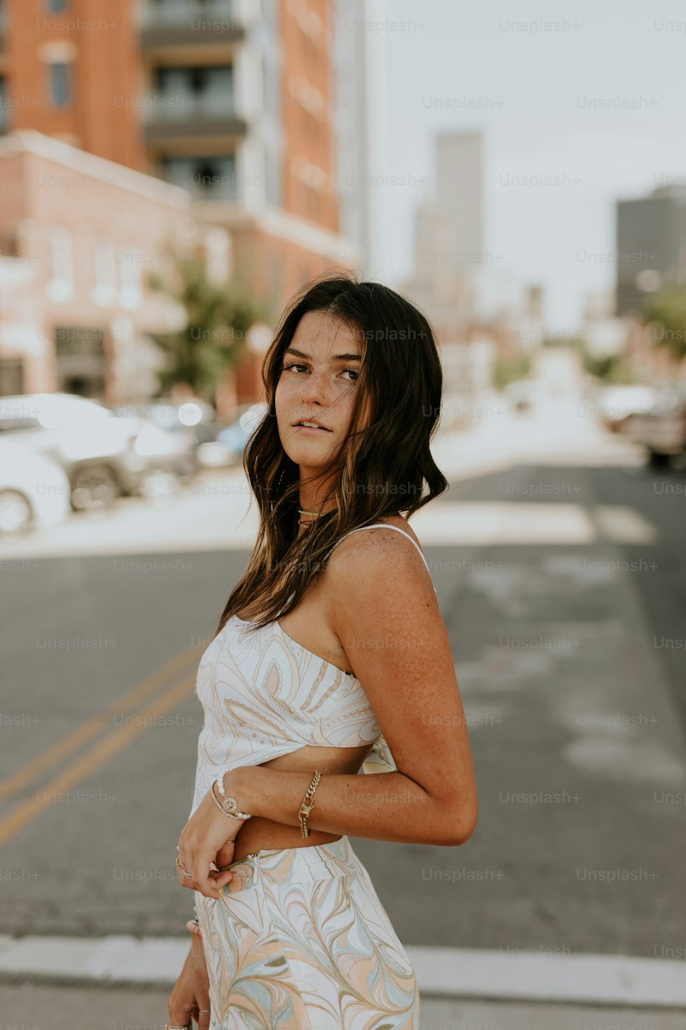 a woman standing on the side of a road