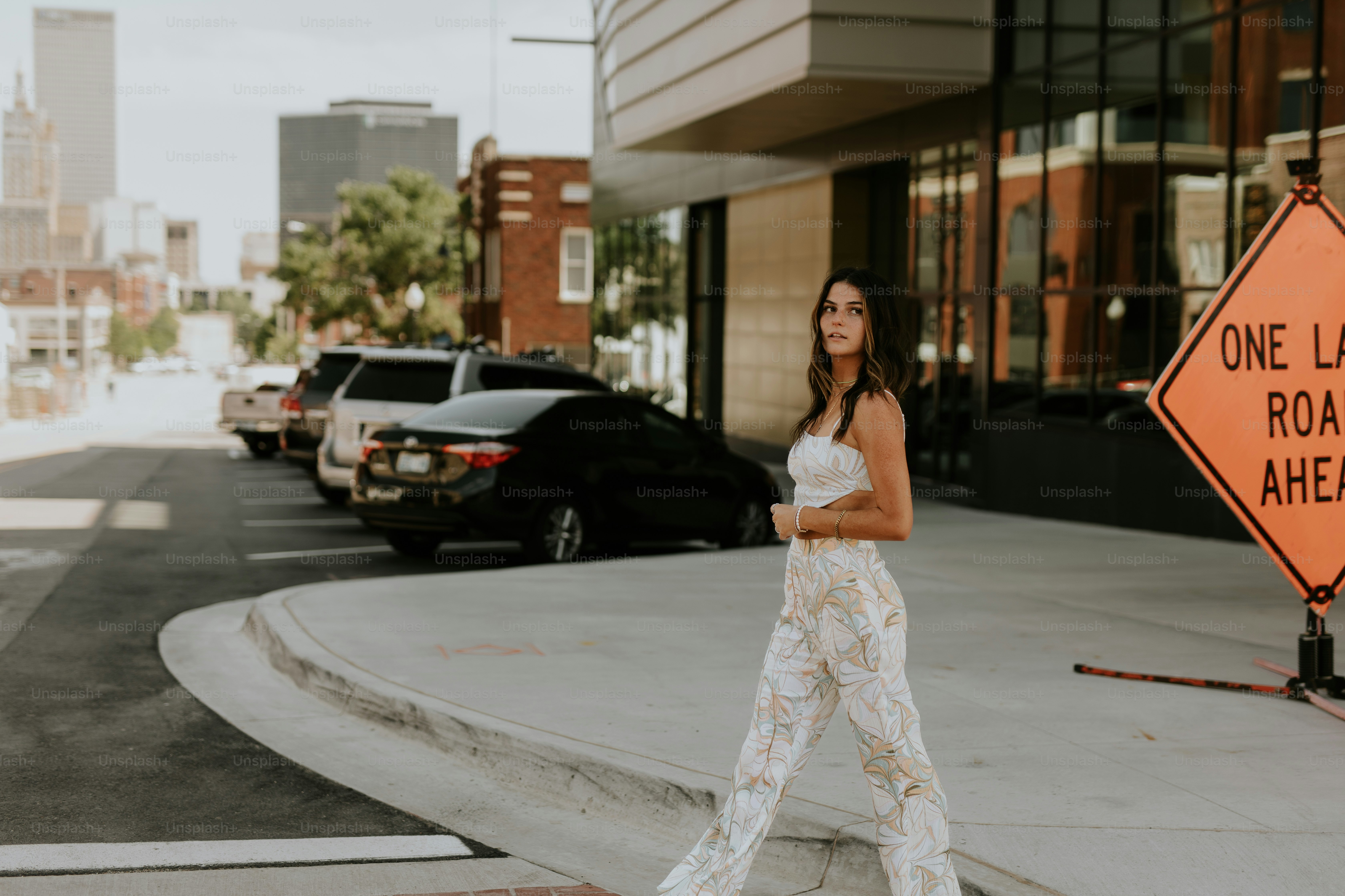 Eine Frau, die die Straße vor einem einspurigen Straßenschild überquert