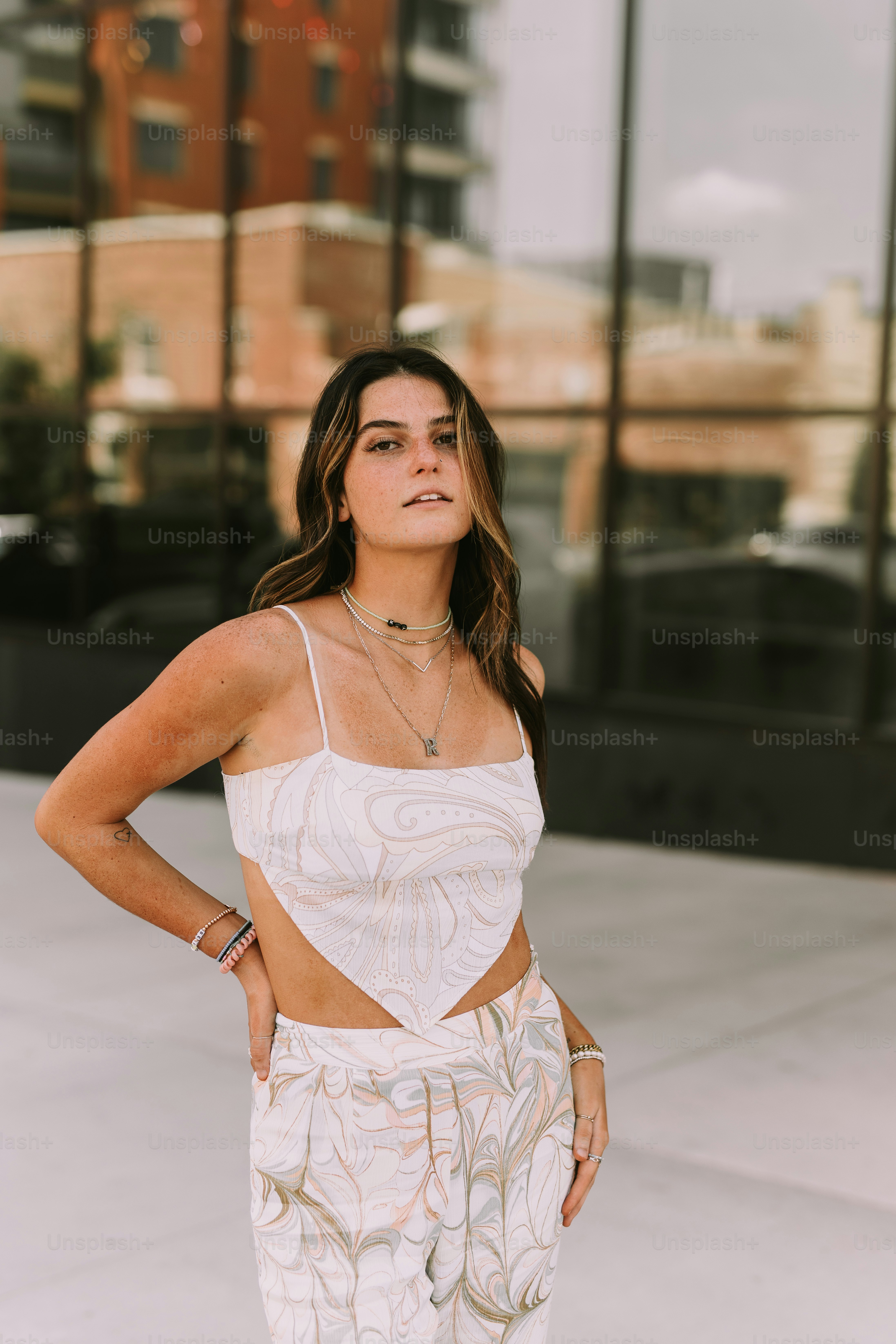Una donna in un top bianco e pantaloni fantasia