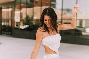 a woman in a white top is dancing