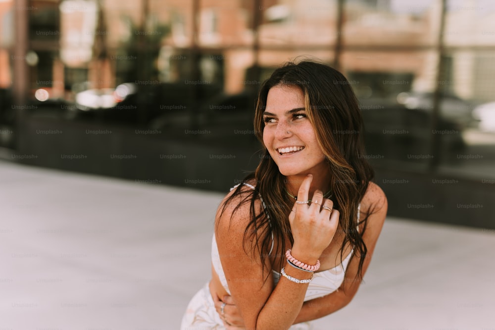 a beautiful young woman in a white dress posing for a picture