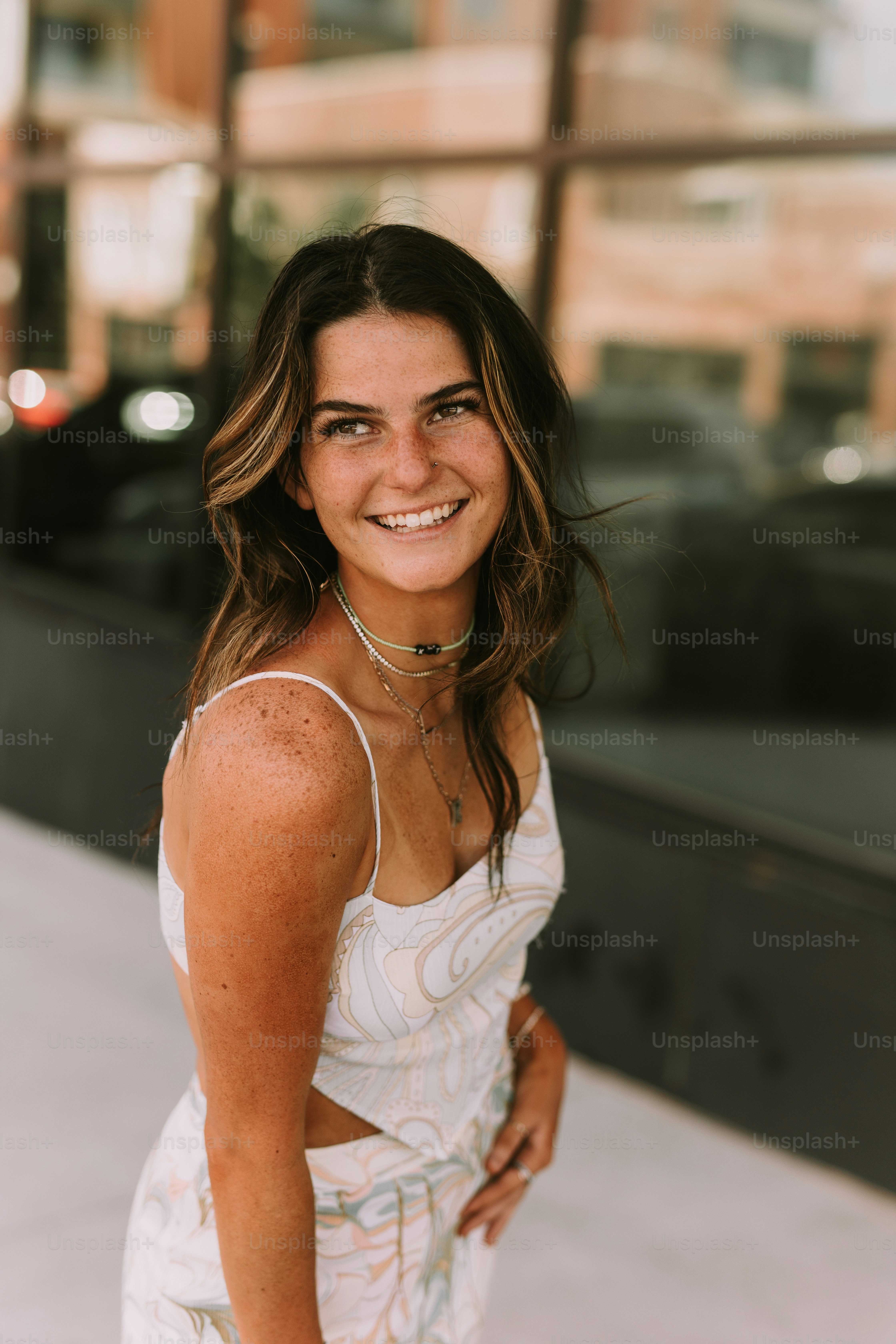 a woman in a white dress smiling for the camera