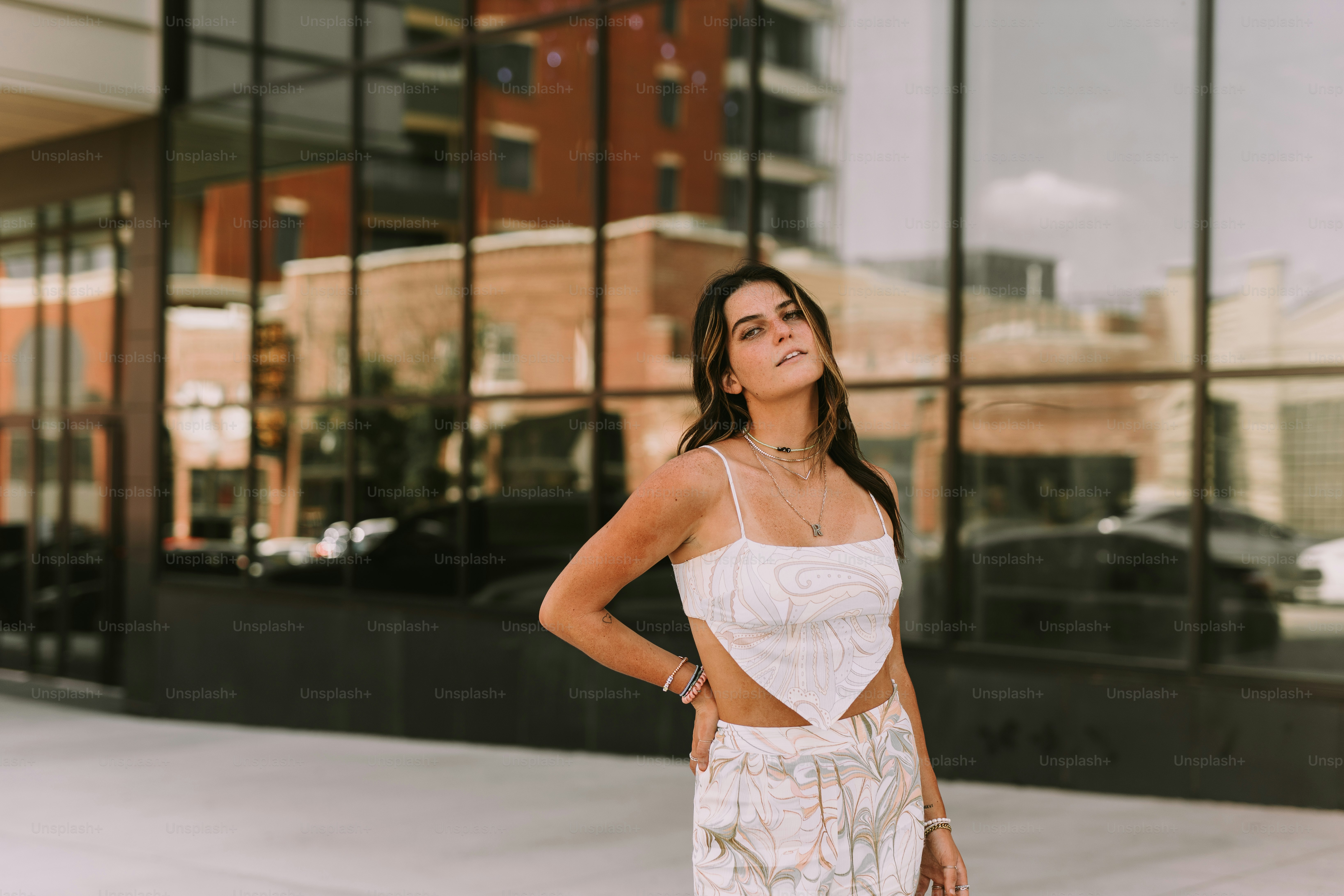 A woman standing on a sidewalk with her hands on her hips photo ...