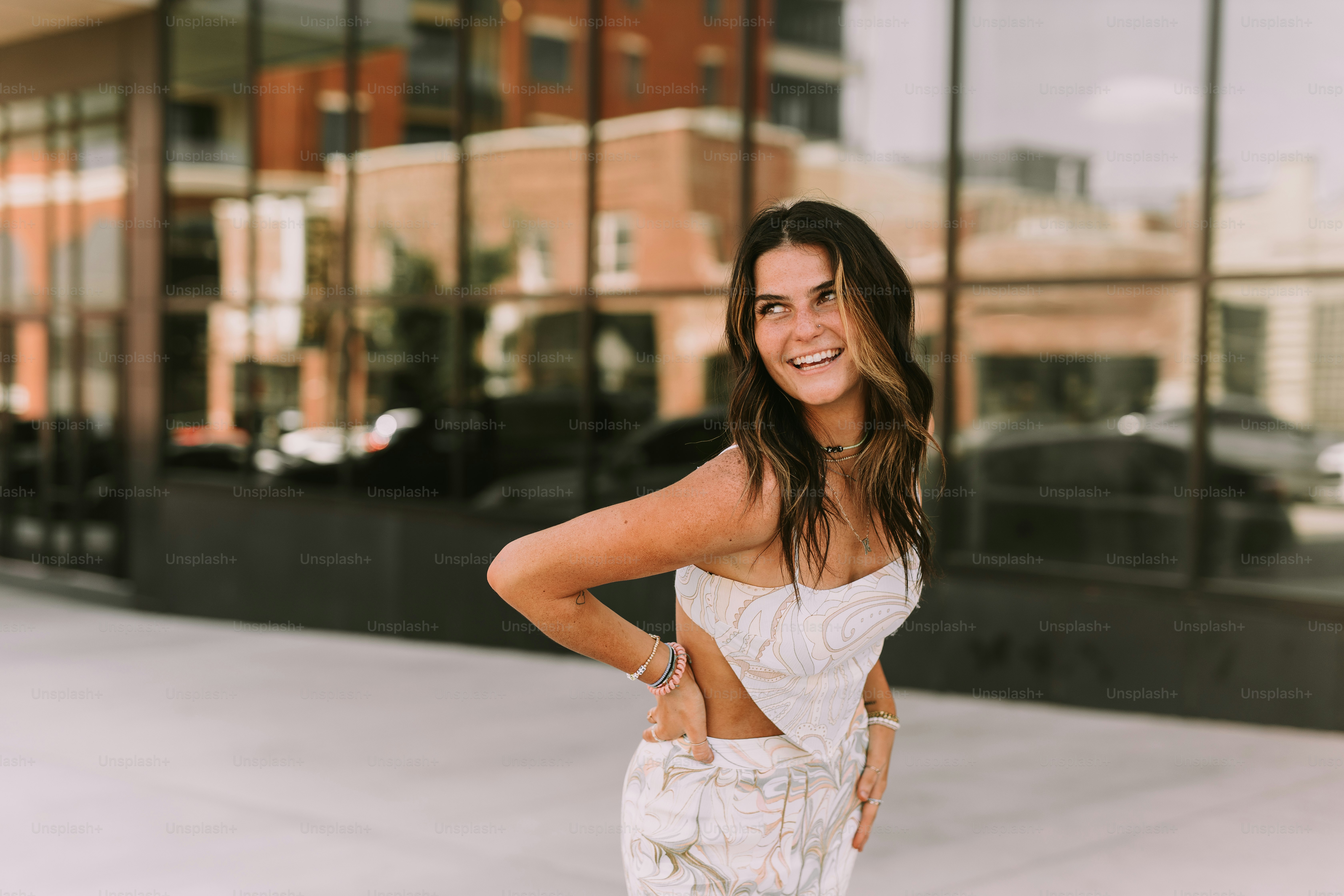 A woman standing on a sidewalk with her hands on her hips photo ...