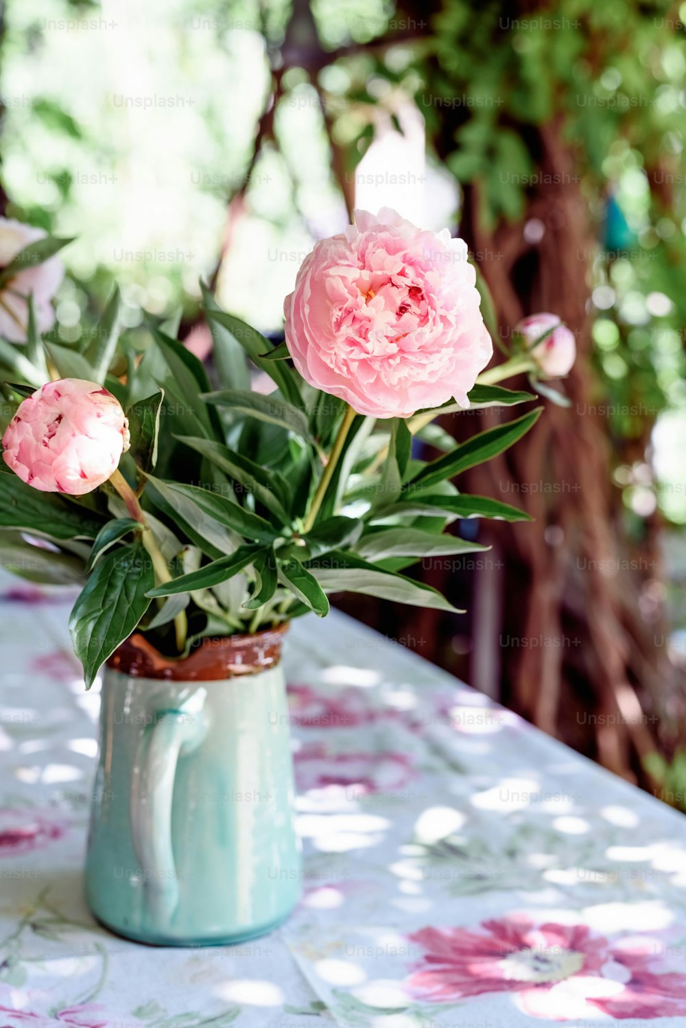 un vase rempli de fleurs roses sur une table