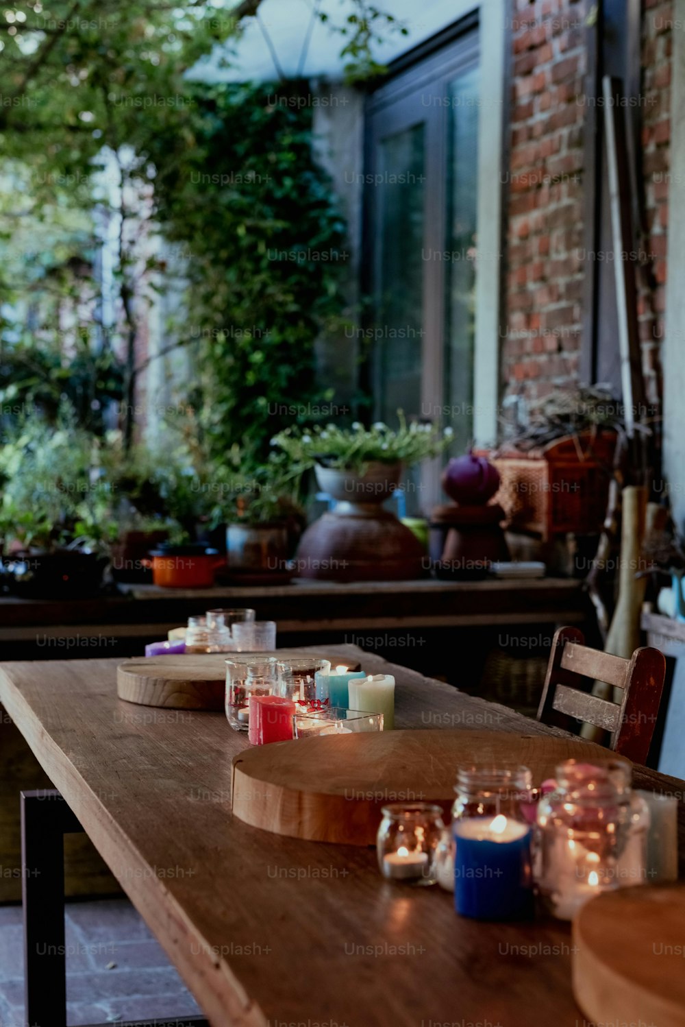 a wooden table topped with candles next to a window