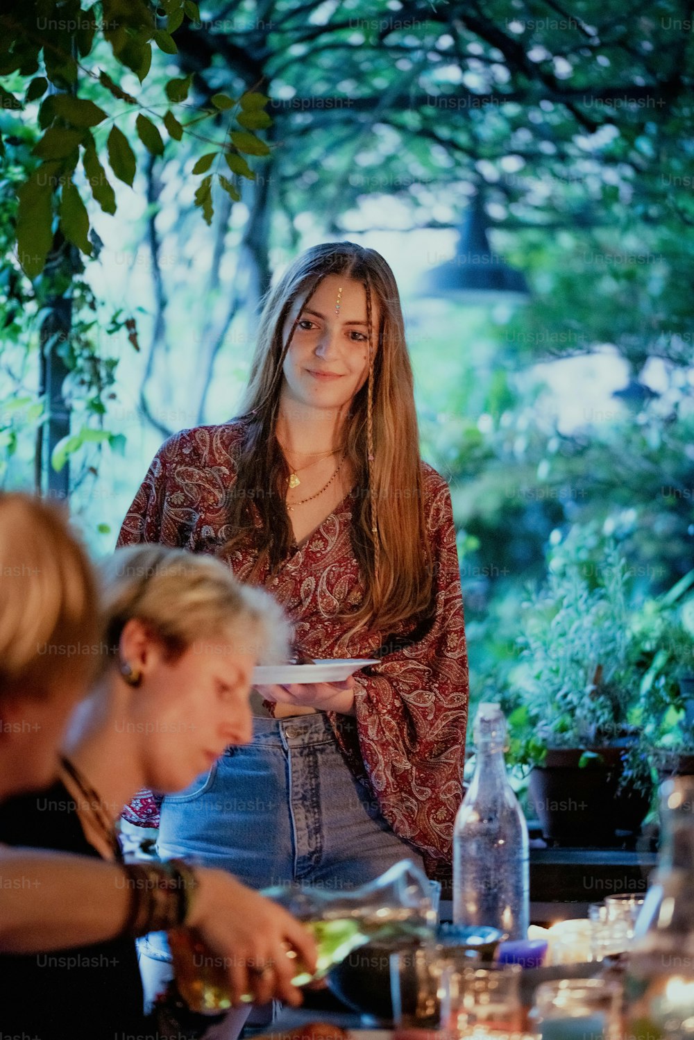 a woman standing at a table with a plate of food