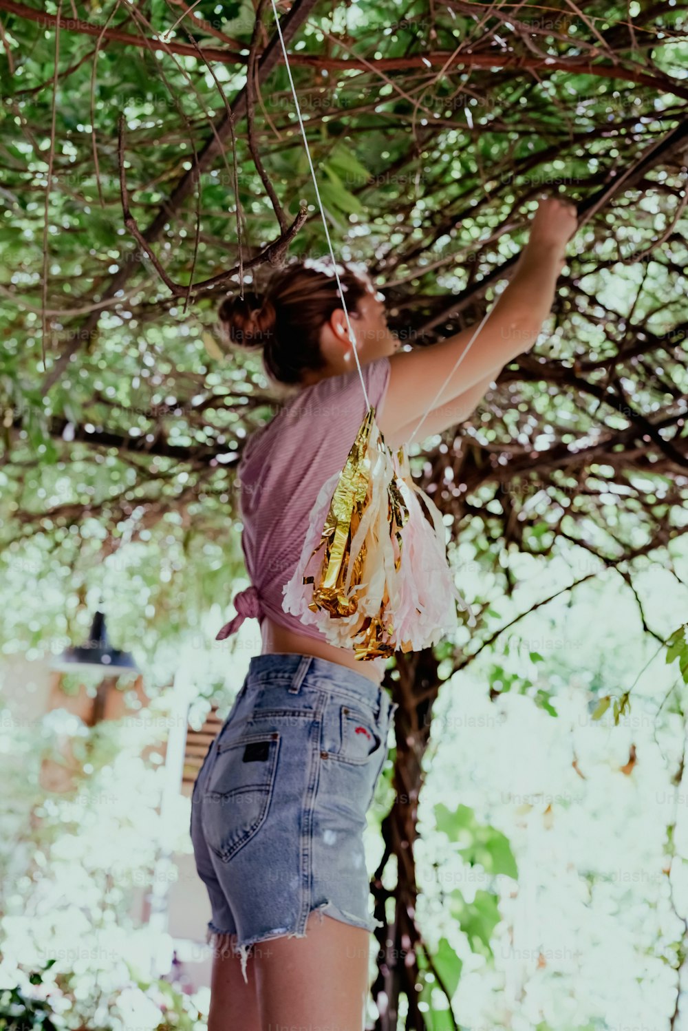 a woman hanging from a tree with a string