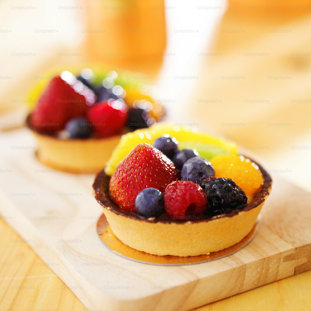 fruit tarts shot with selective focus on wood board