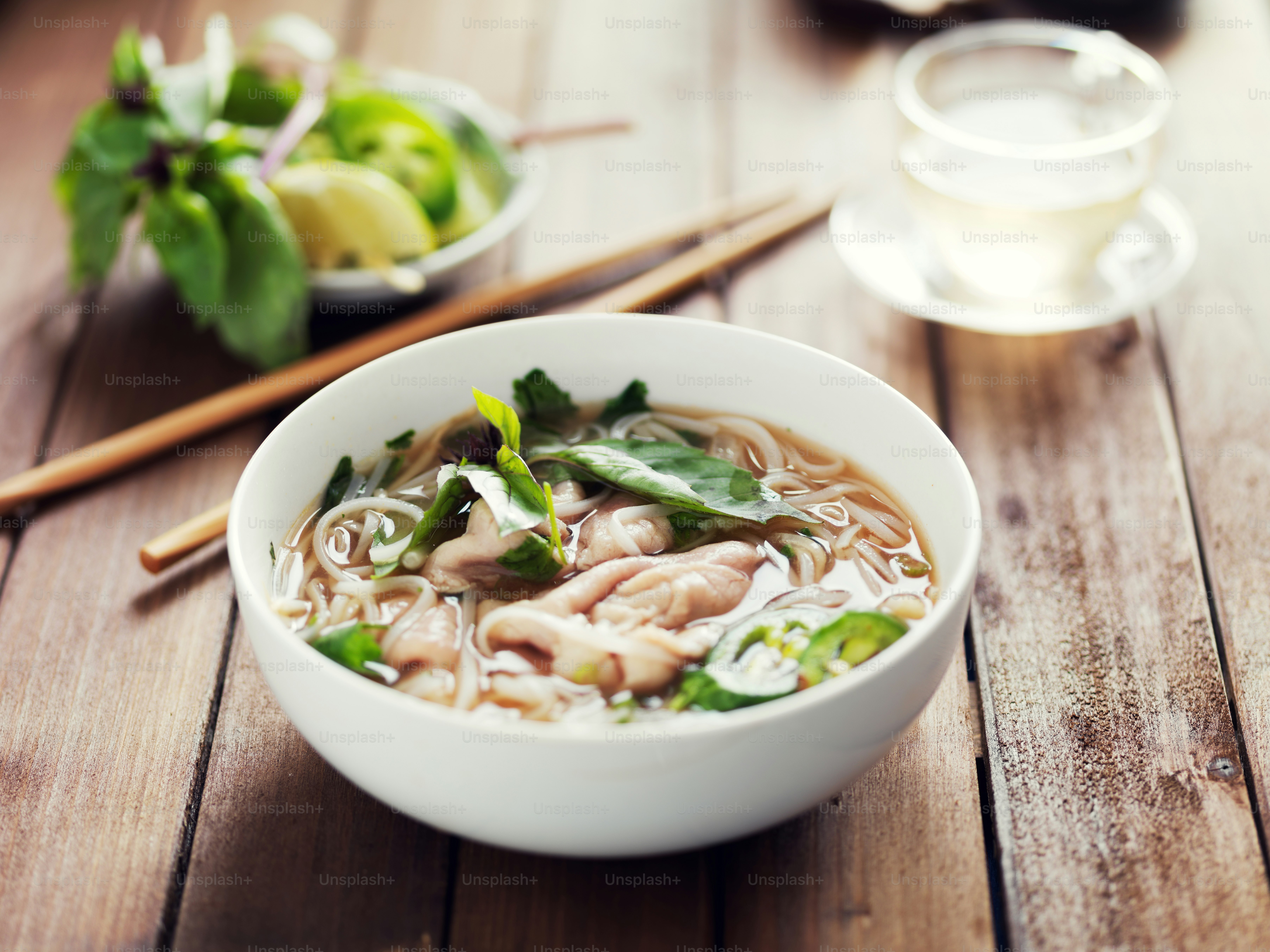 vietnamese beef pho with chopsticks on wooden table shot close up
