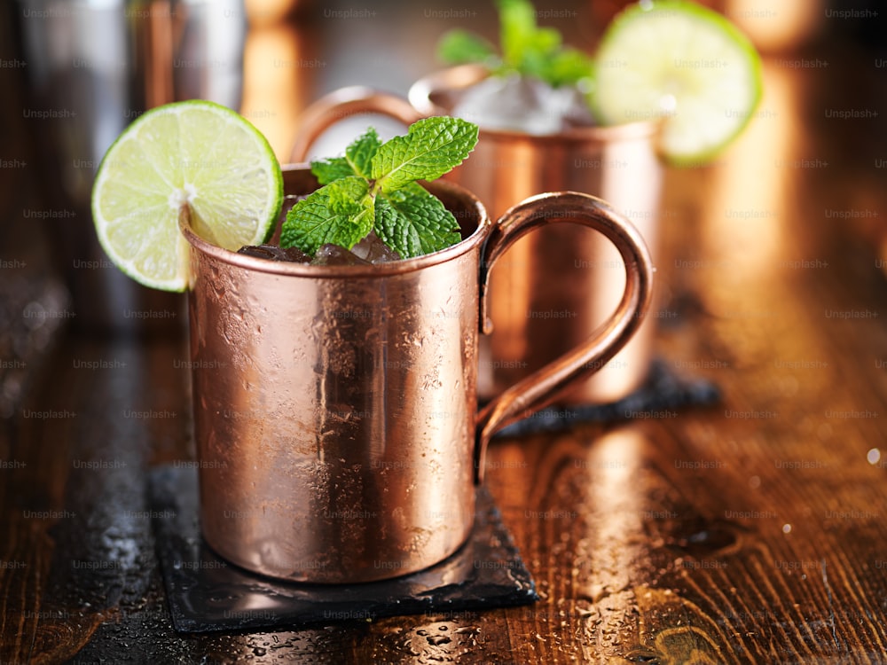 Cóctel Moscow Mule en taza de cobre con guarnición de menta y lima