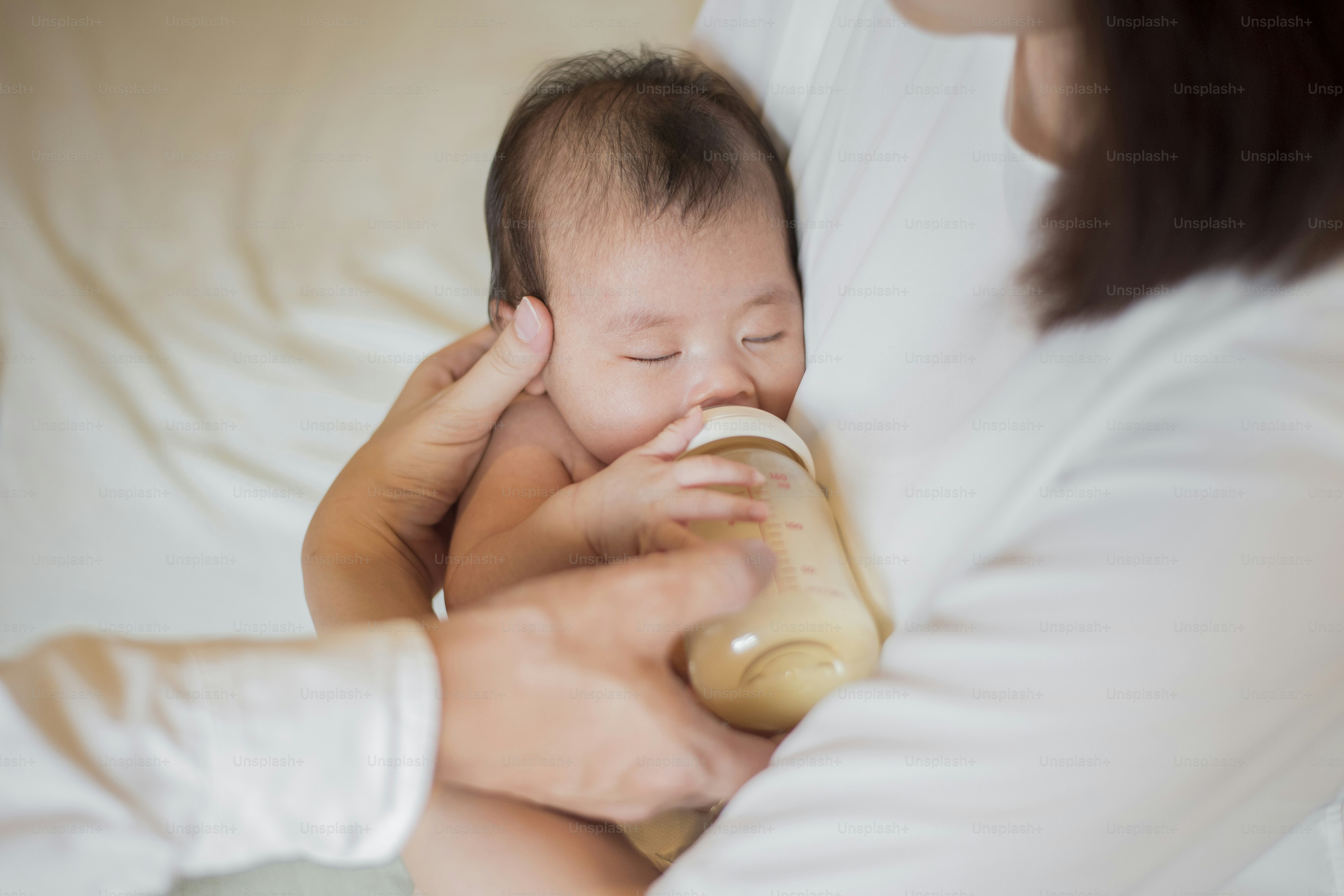 Newborn baby girl is drinking milk by  her mother