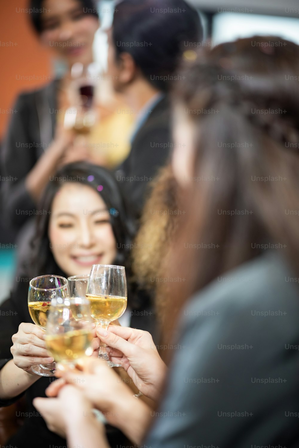 Portez un toast au succès. Groupe de gens d’affaires trinquant avec du champagne et souriant tout en se tenant près de chacun