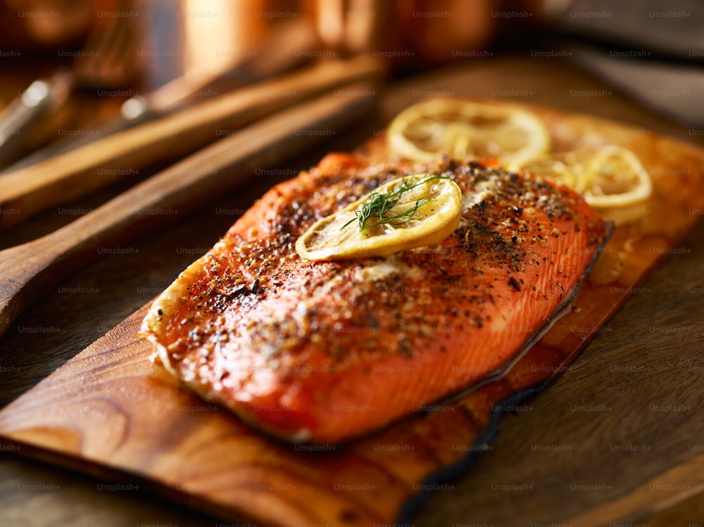 cooked cedar planked salmon with lemon and dill cooling down and ready to eat
